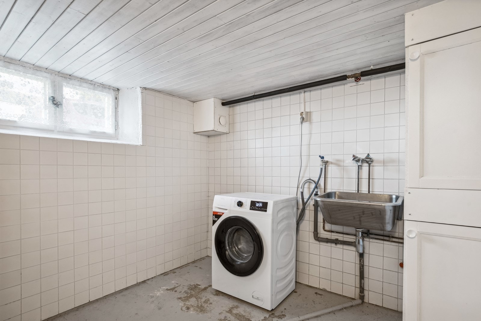 Praktisk vaskekjeller med flere muligheter. Inneholder vaskekum, arbeidsbenk med laminerte overflater og opplegg til vaskemaskin. Galleribilde