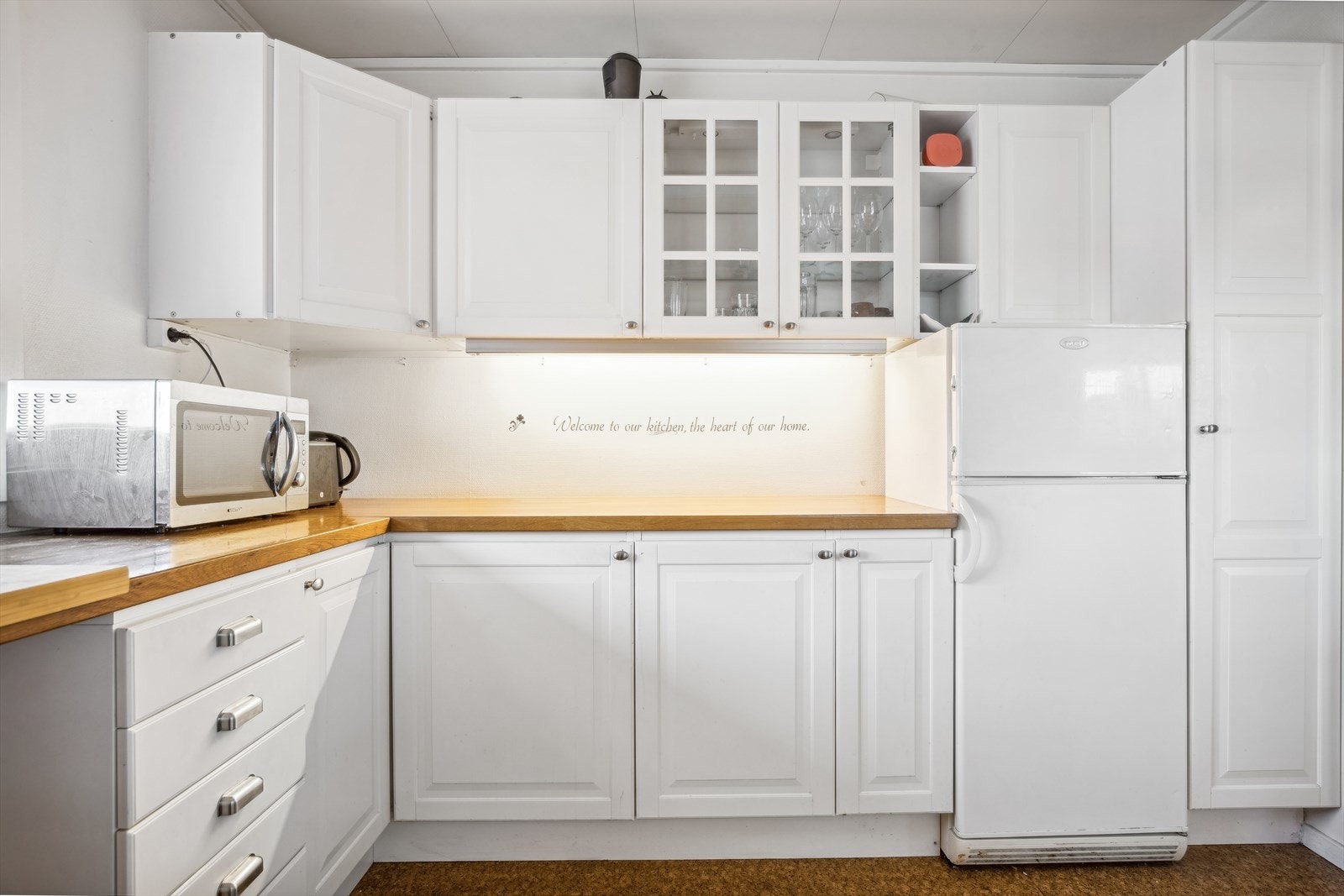 Godt arbeidslys under overskap. Kjøkkenet har frittstående hvitevarer. Galleribilde