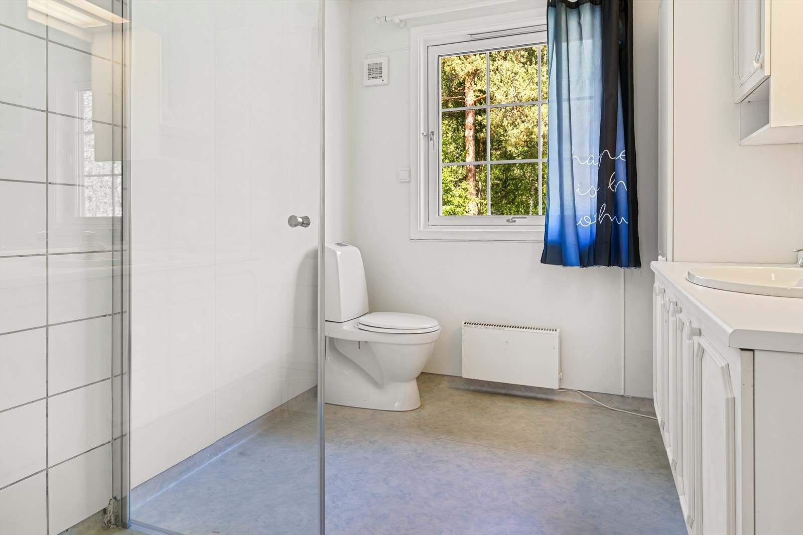 Badet er innredet med dusjvegger, toalett og baderomsinnredning med servant. Galleribilde