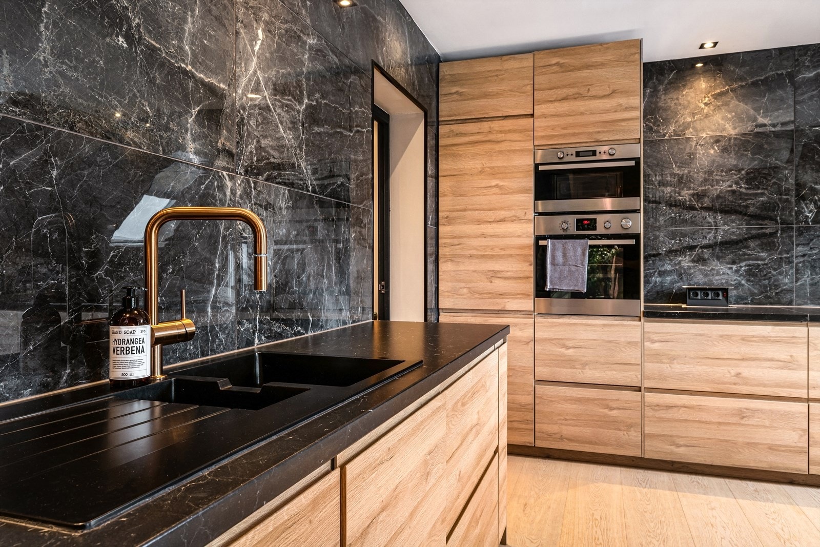 Påkostet kjøkken fra 2023 med mørk benkeplate, fliser i natursteinutførelse og god arbeidsplass. Galleribilde