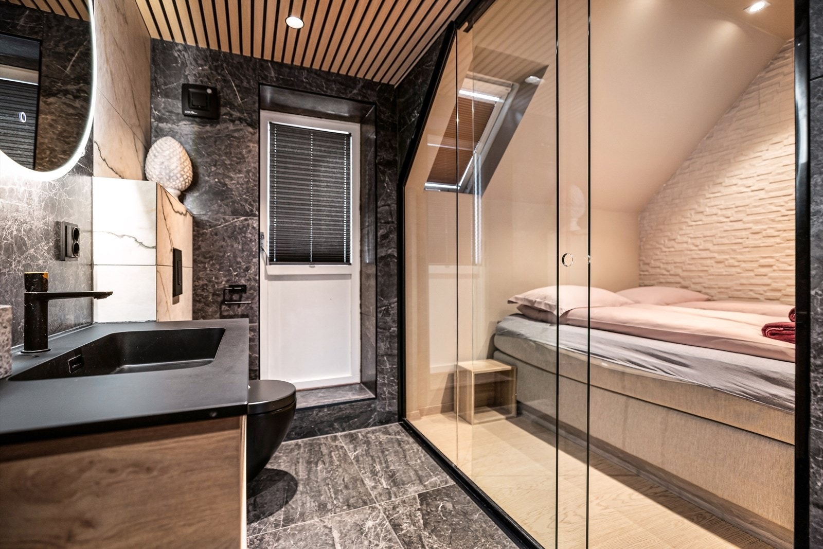 Glassveggen skaper en unik helhet mellom badet og soverommet. Galleribilde