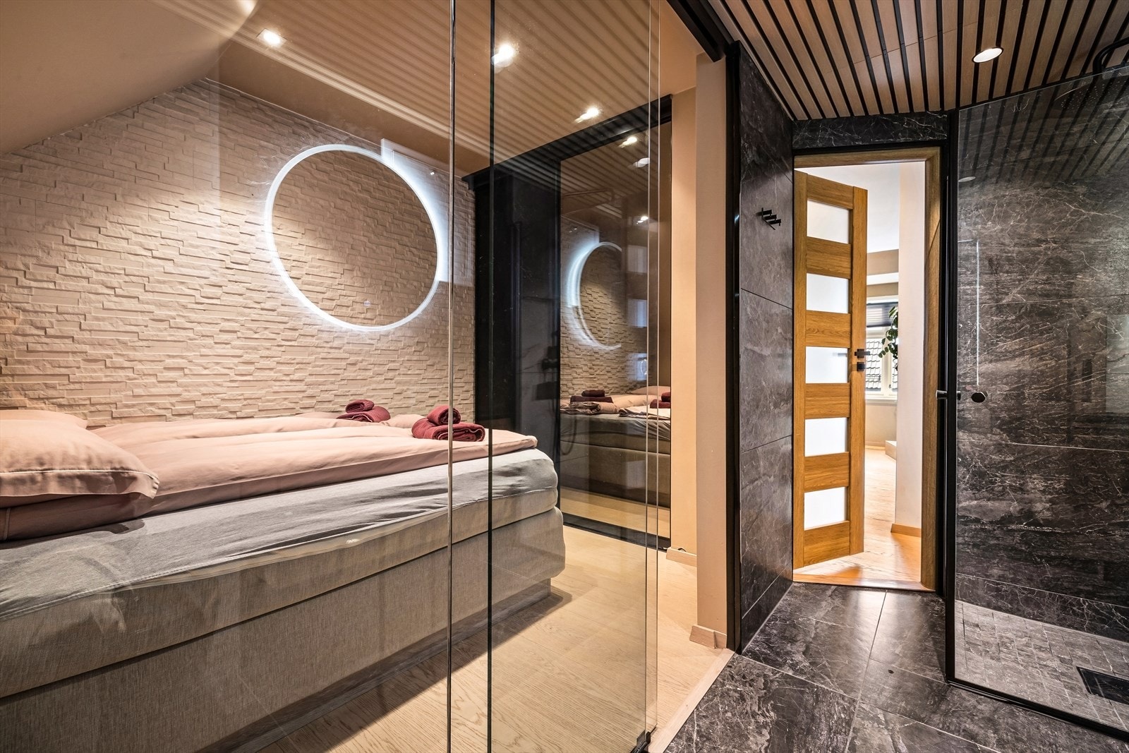 Rommet har en moderne og særpreget løsning med glassvegg mot badet. Dette gir ekstra lysinnslipp og et eksklusivt preg. Galleribilde