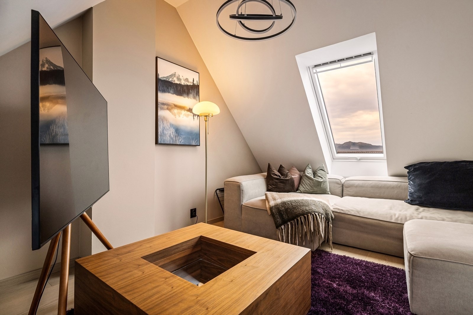 God plass til sofakrok og TV-hjørne, med naturlig lys fra takvinduene. Galleribilde