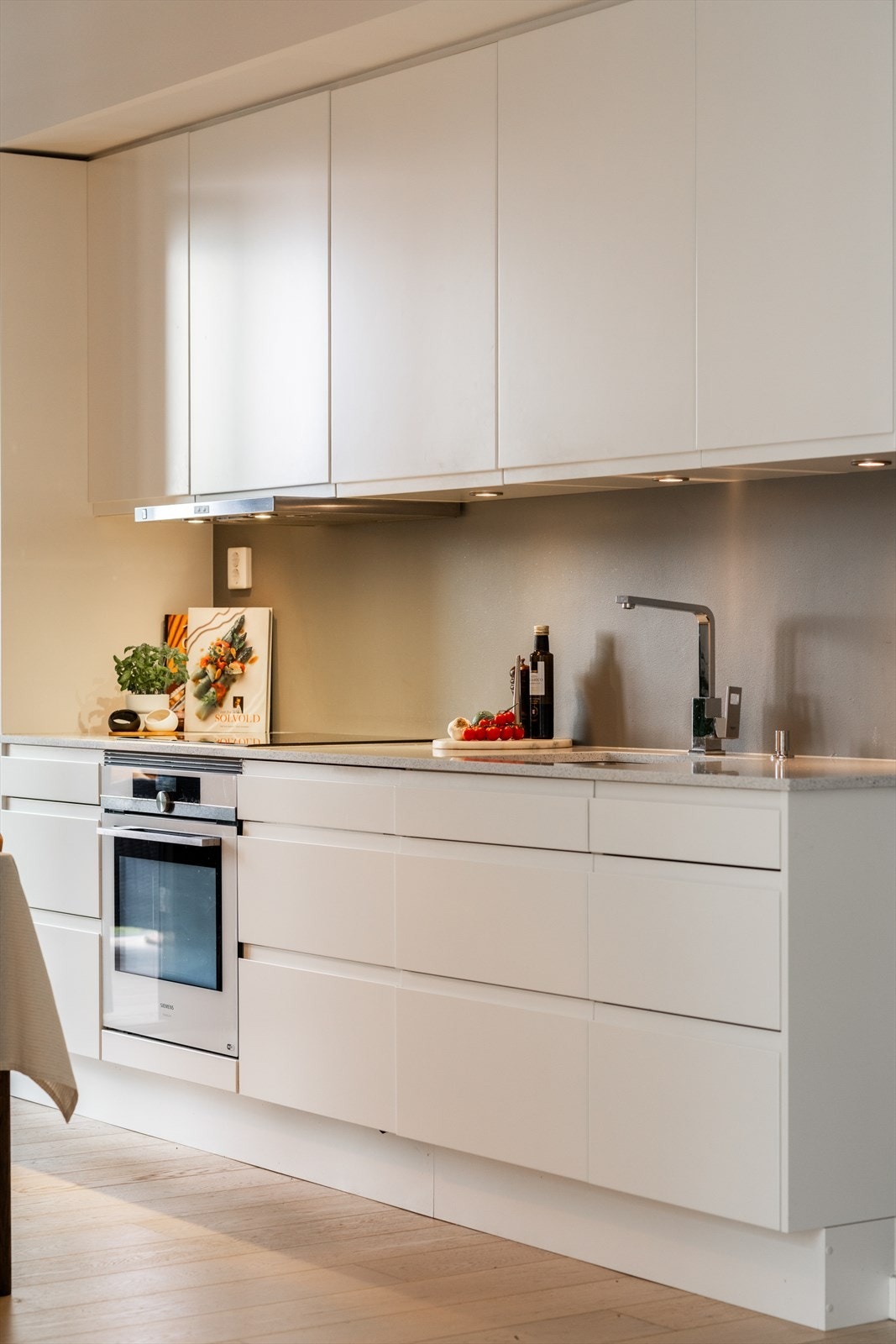 Integrerte hvitevarer med platetopp, komfyr, kombiskap og oppvaskmaskin. I tillegg er det kjøkkenviften koblet mot balansert anlegg, noe som sørger for godt avtrekk og godt inneklima. Galleribilde