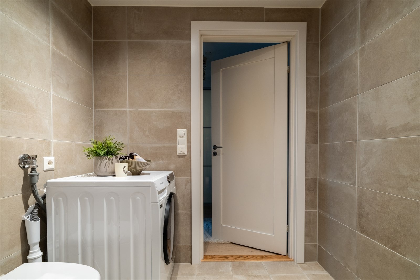 Videre har man veggmontert toalett og opplegg for vaskemaskin. Galleribilde