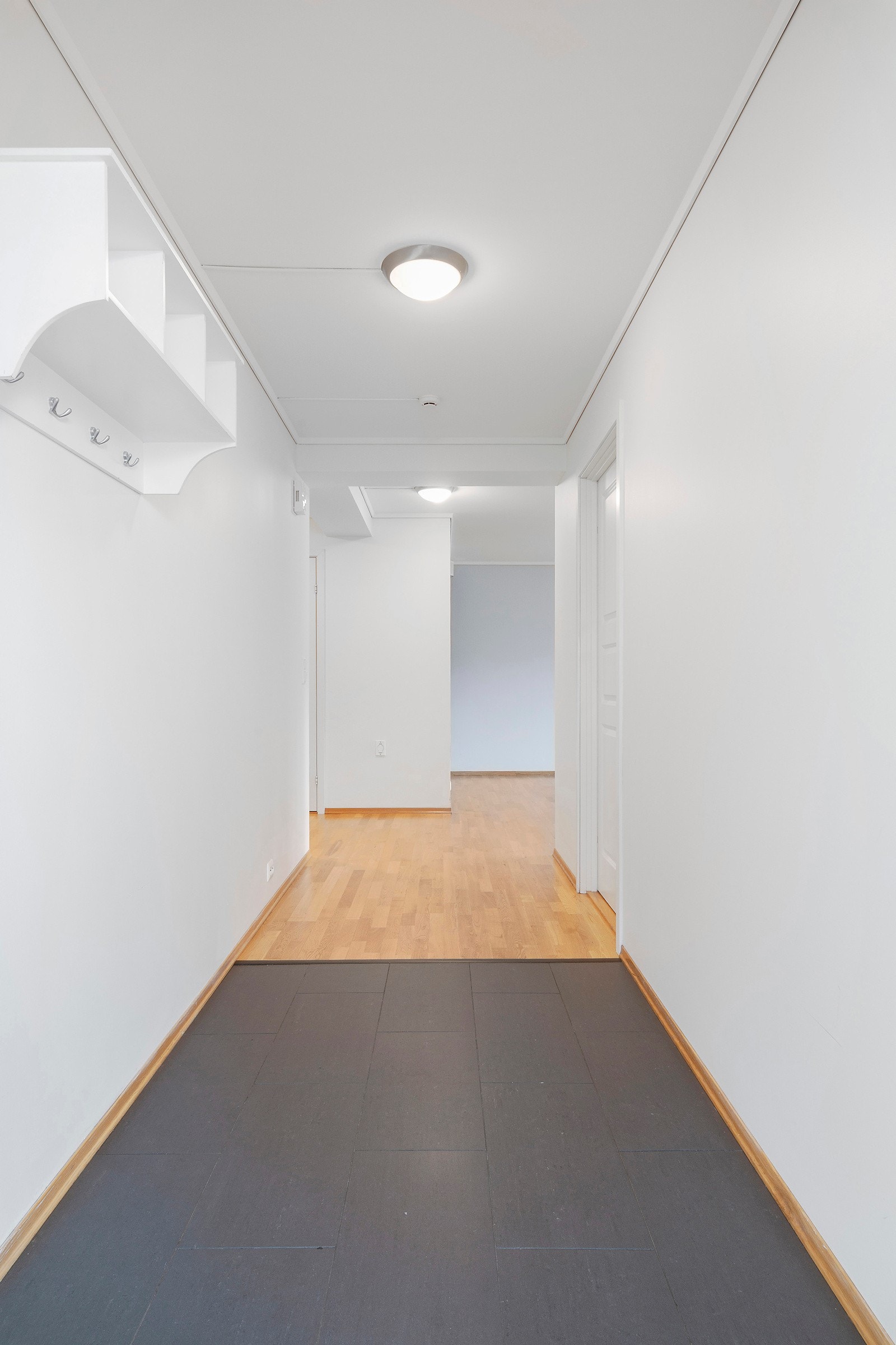 Flislagt gang med gode muligheter for oppbvaring av sko og yttertøy. Galleribilde