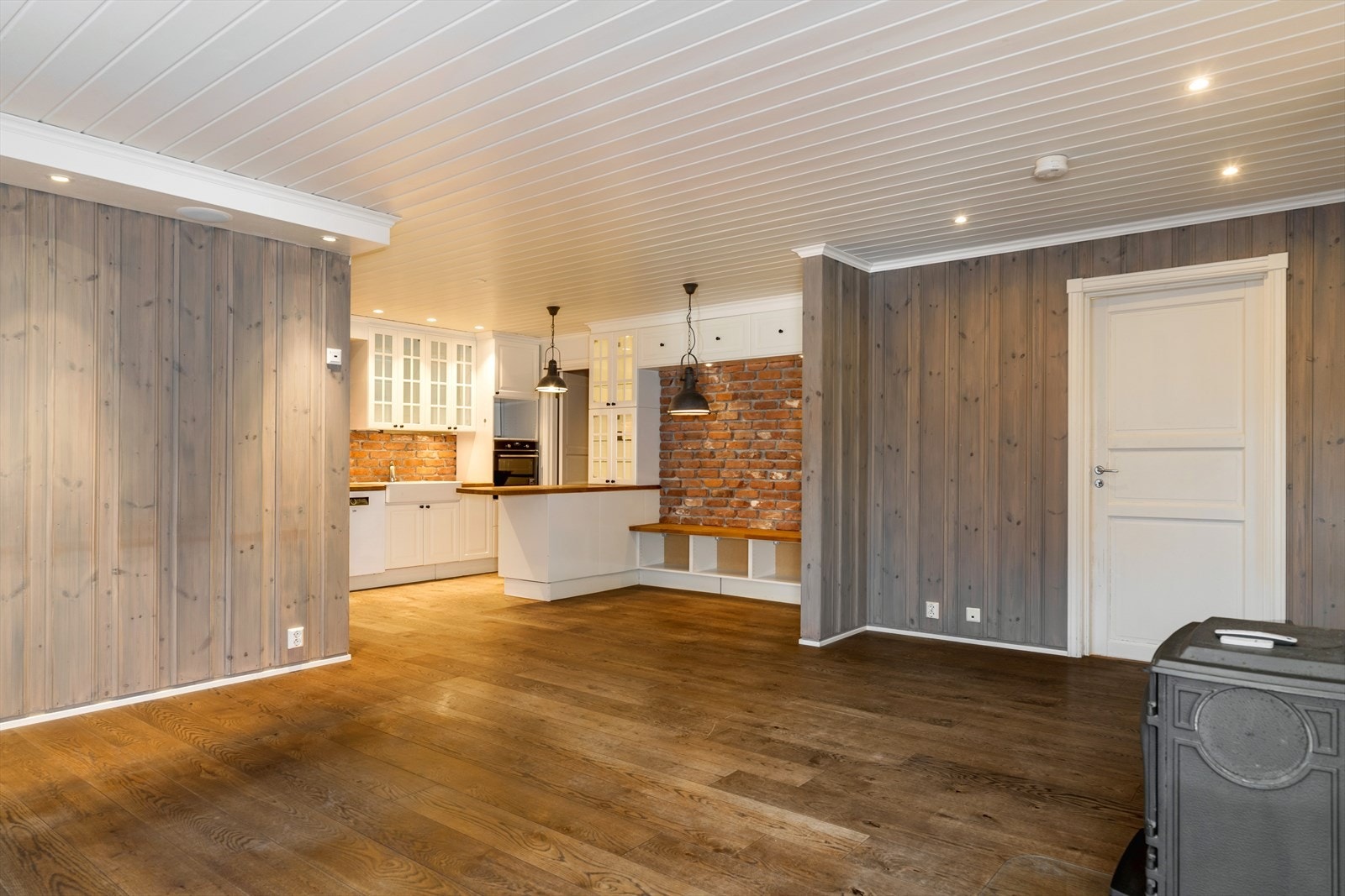 Åpen løsning mellom stue og kjøkken gir et naturlig samlingspunkt i boligen. Galleribilde