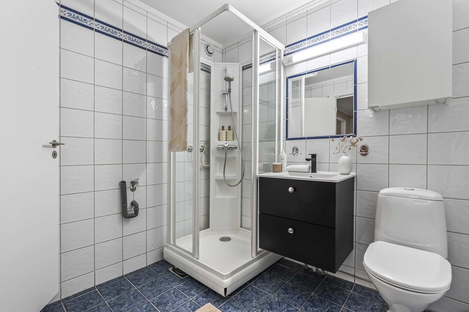 Dusjkabinett, baderomsinnredning, innmurt speil og gulvstående toalett. Galleribilde