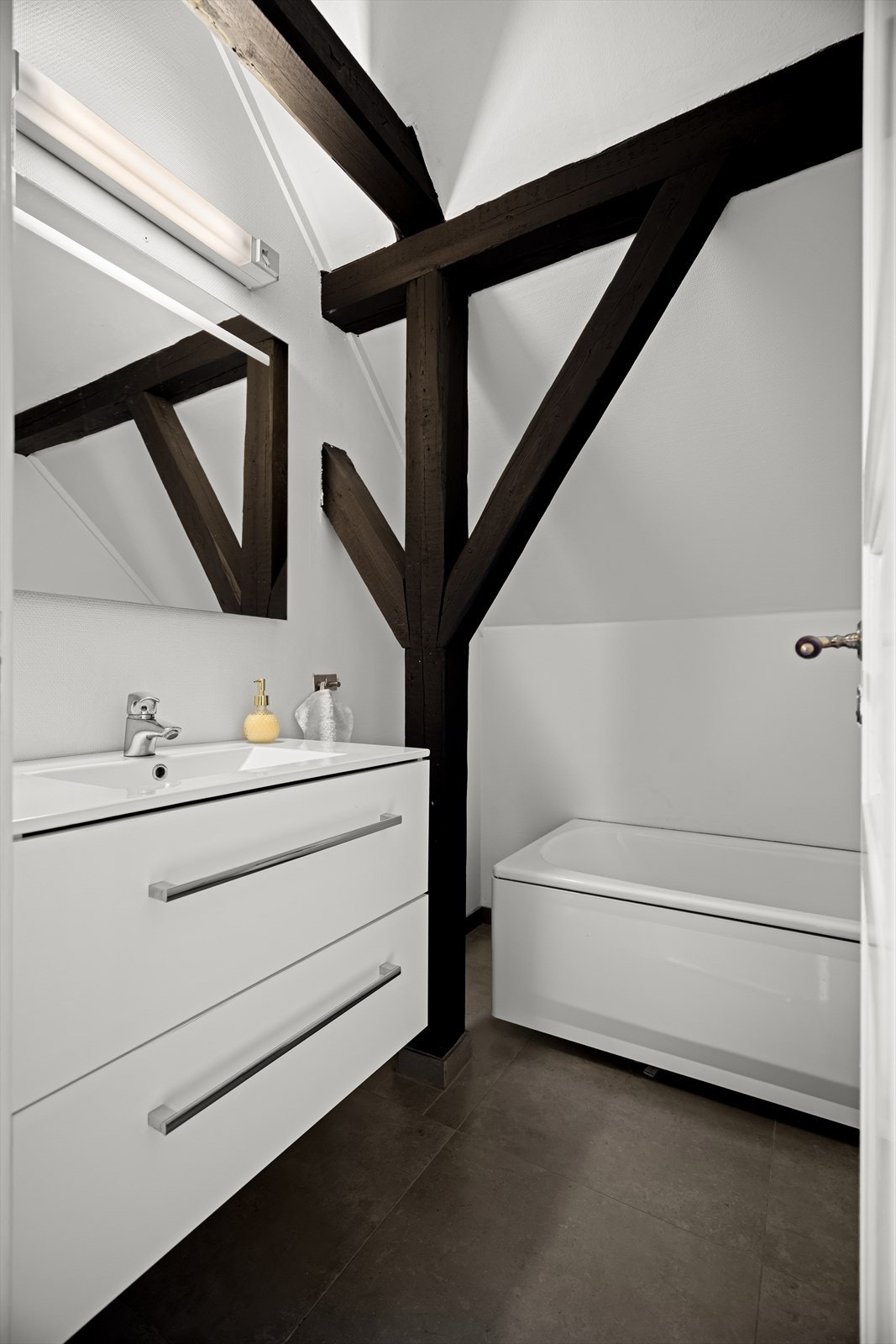 Badet består av servant med skuffer, toalett og badekar Galleribilde