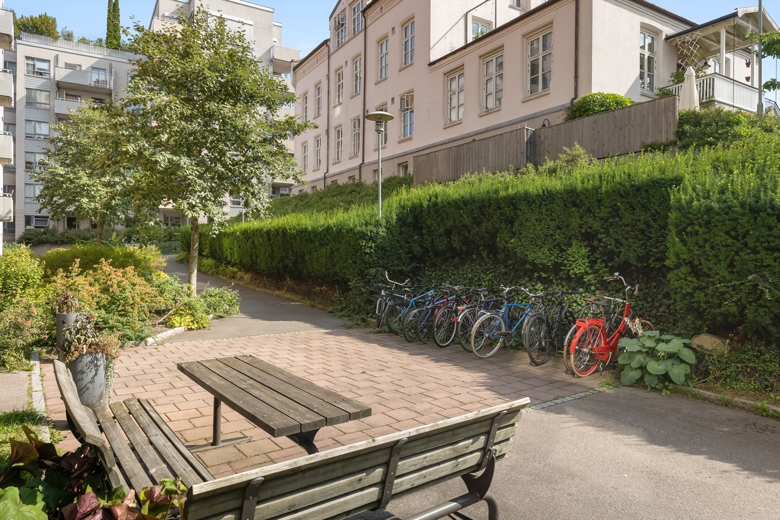 Bakgården er pent opparbeidet med buskebeplantning, asfaltert gangvei samt sittegrupper og sykkelstativ. Galleribilde