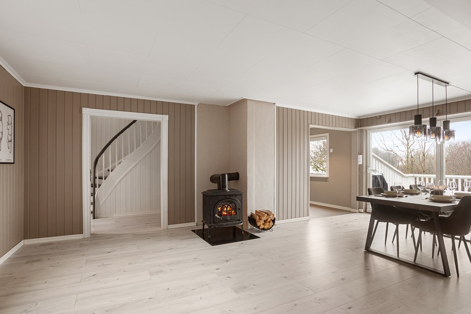 Videre adkomst ti spisestue med vedovn som bidrar til en behagelig varme i oppholdsrommet Galleribilde
