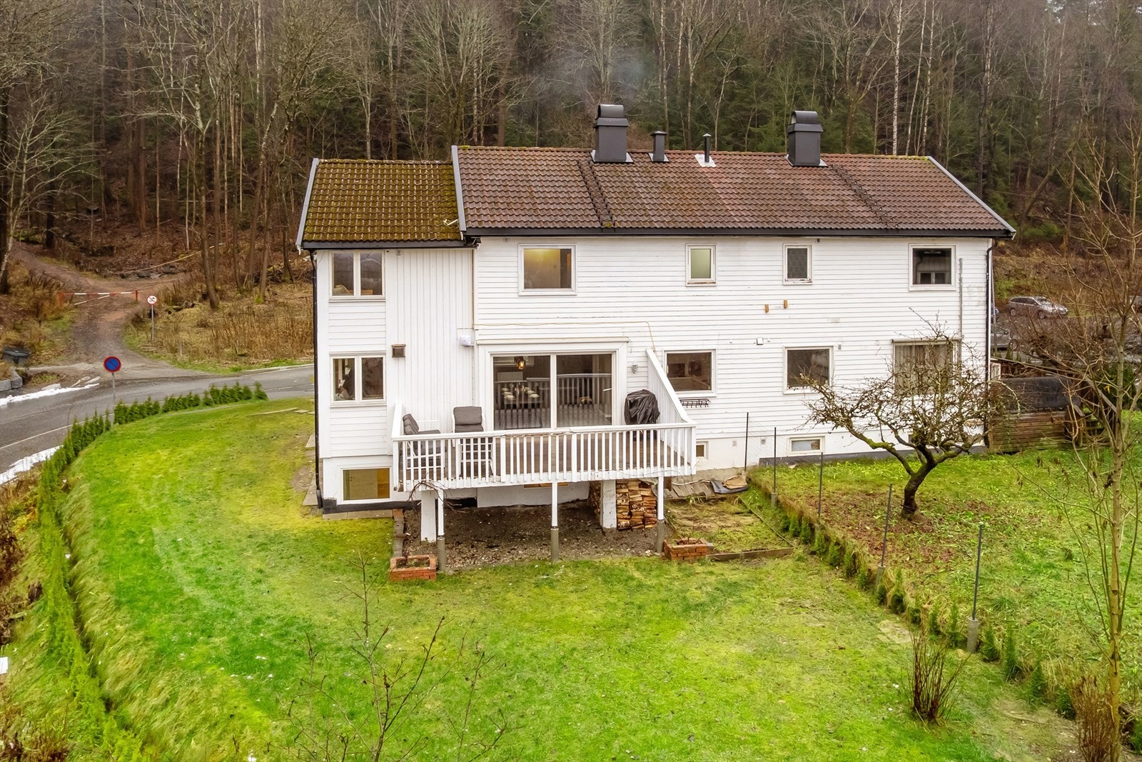 Boligen er omkranset av hage, skog og mark Galleribilde