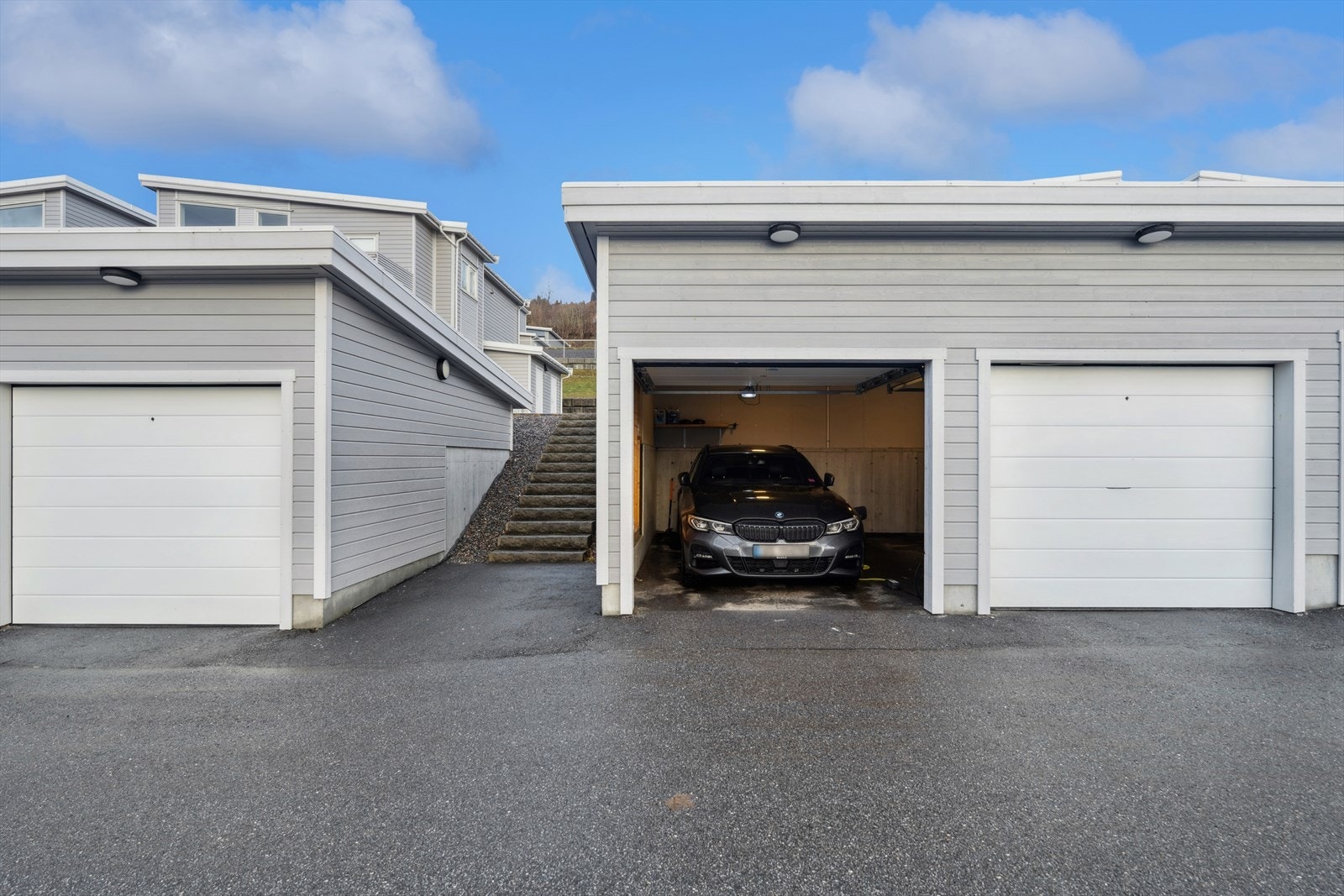 Parkeringsareal delt med innehaver av garasjeplassen på østsiden. Leddet stålport med trådløs portåpner, tilgang til strøm og mulighet for montering av elbil-lader. Galleribilde