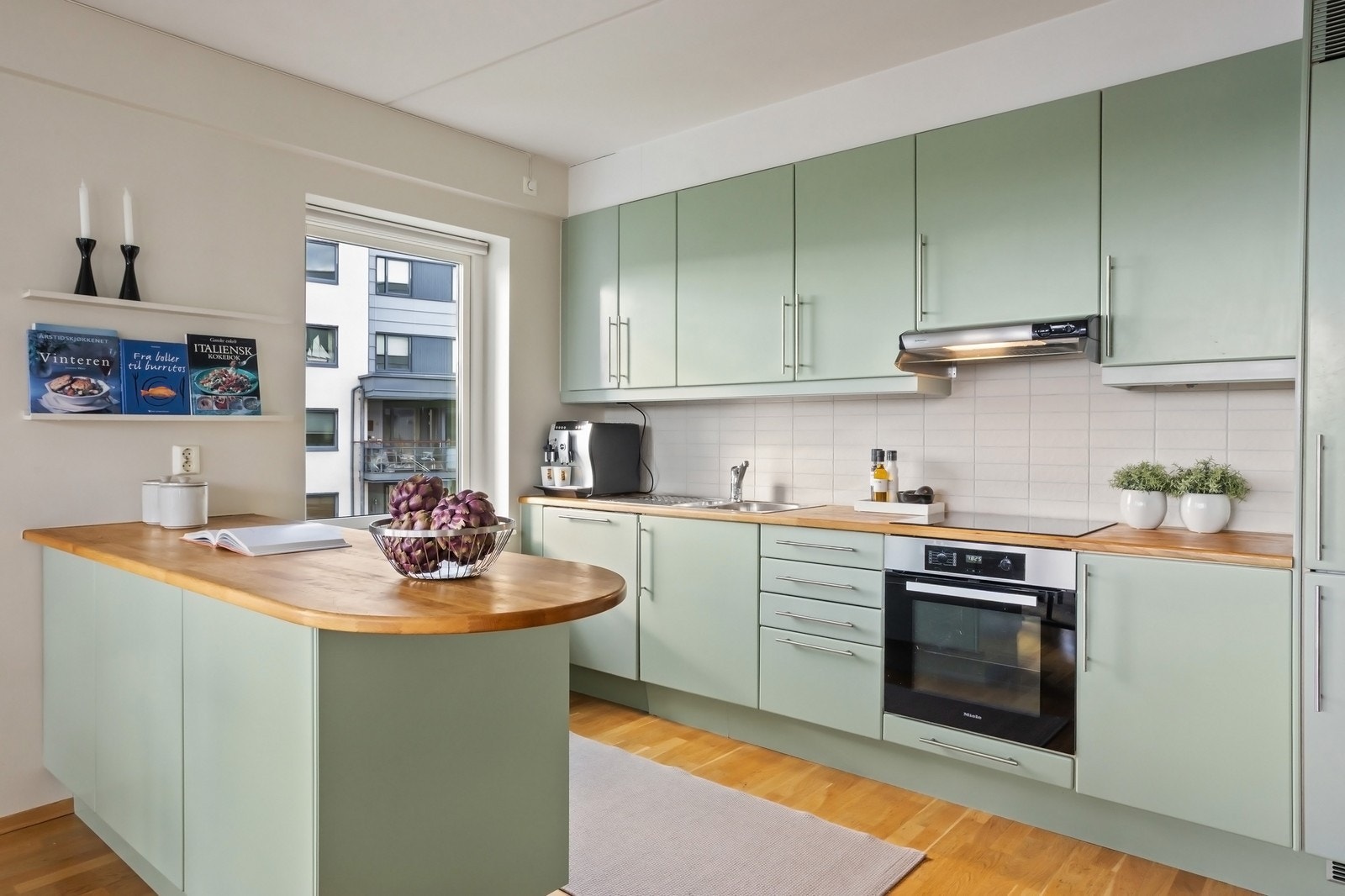 Kjøkkeninnredning med glatte fronter, benkeplate av heltre og oppvaskkum av stål Galleribilde