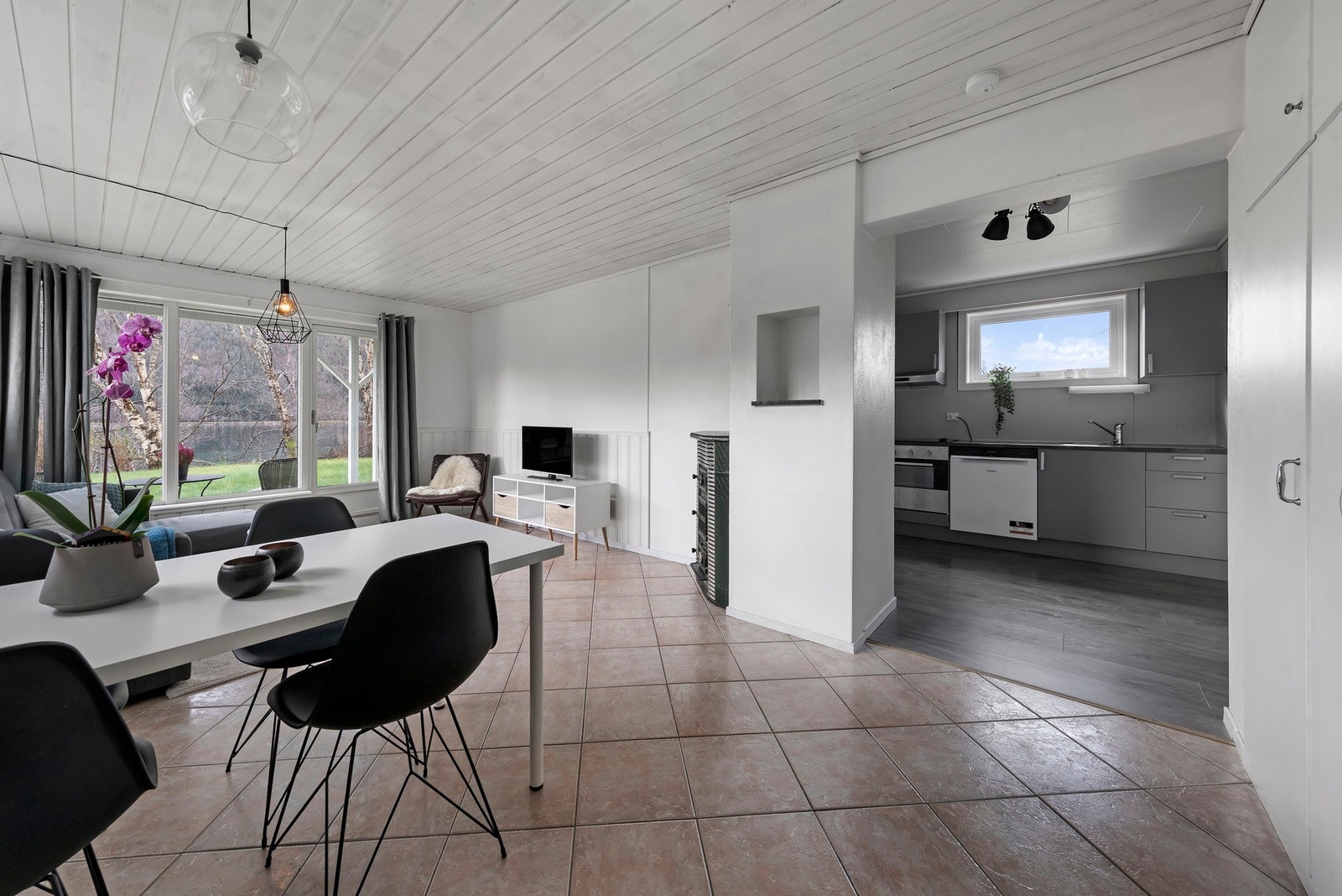 Stue i sokkelleilighet har flislagt gulv Galleribilde