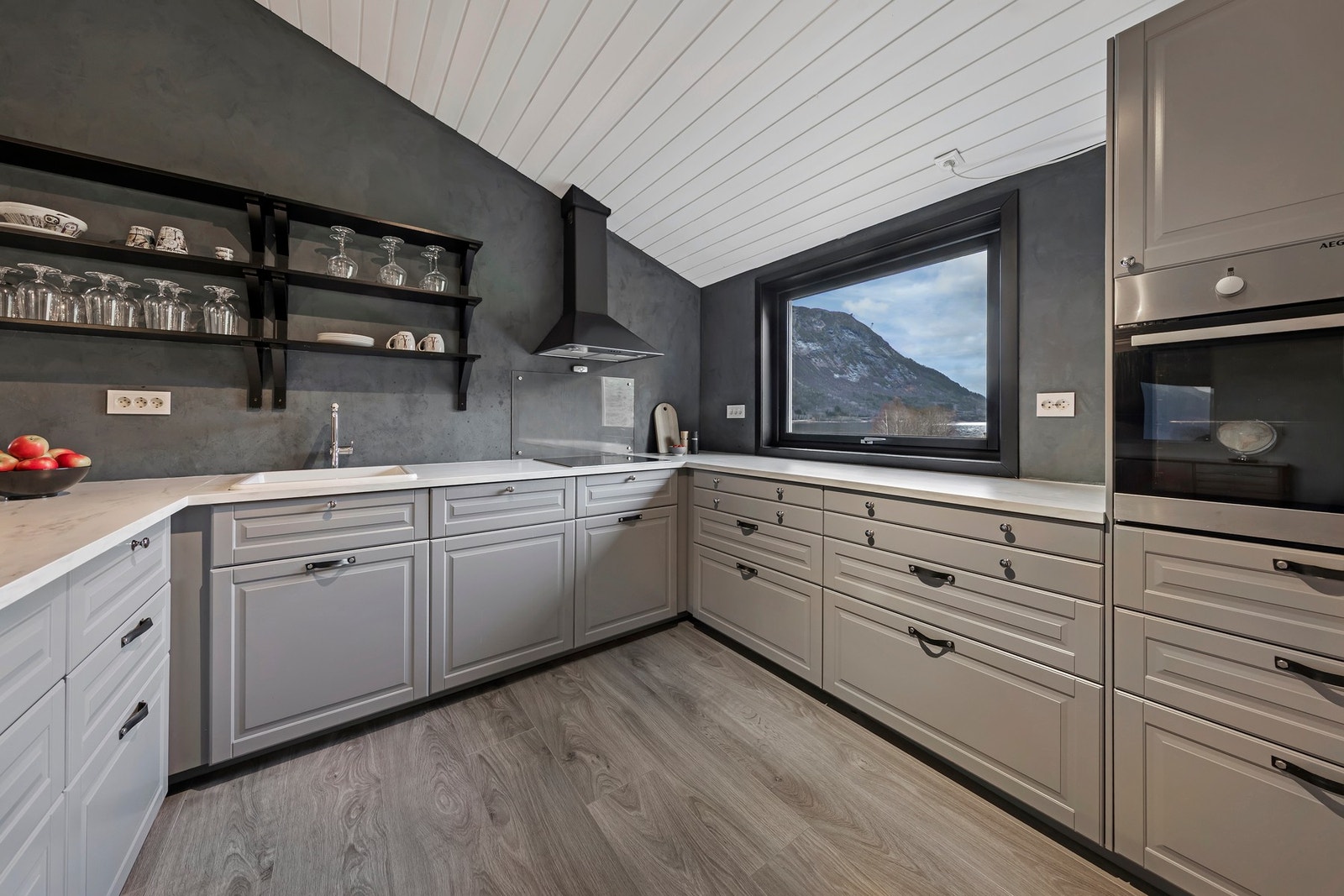 Integrerte hvitevarer som induksjonstopp, stekeovn og oppvaskmaskin. Det er tilgang til kjølerommet fra kjøkkenet Galleribilde