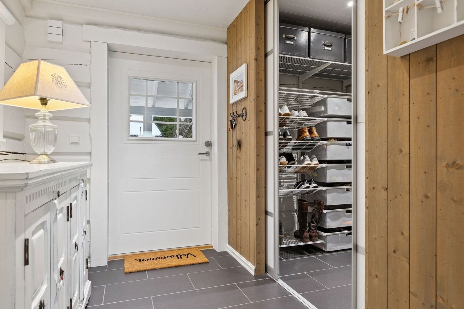 Praktisk skyvedørsløsning inn til funksjonelt og plassbesparende oppbevaringsrom for yttertøy. Galleribilde