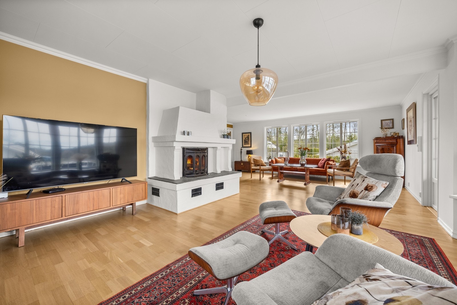 Stor og romslig stue med vedovn. Store vindusflater. Kan leies ut møblert. Galleribilde