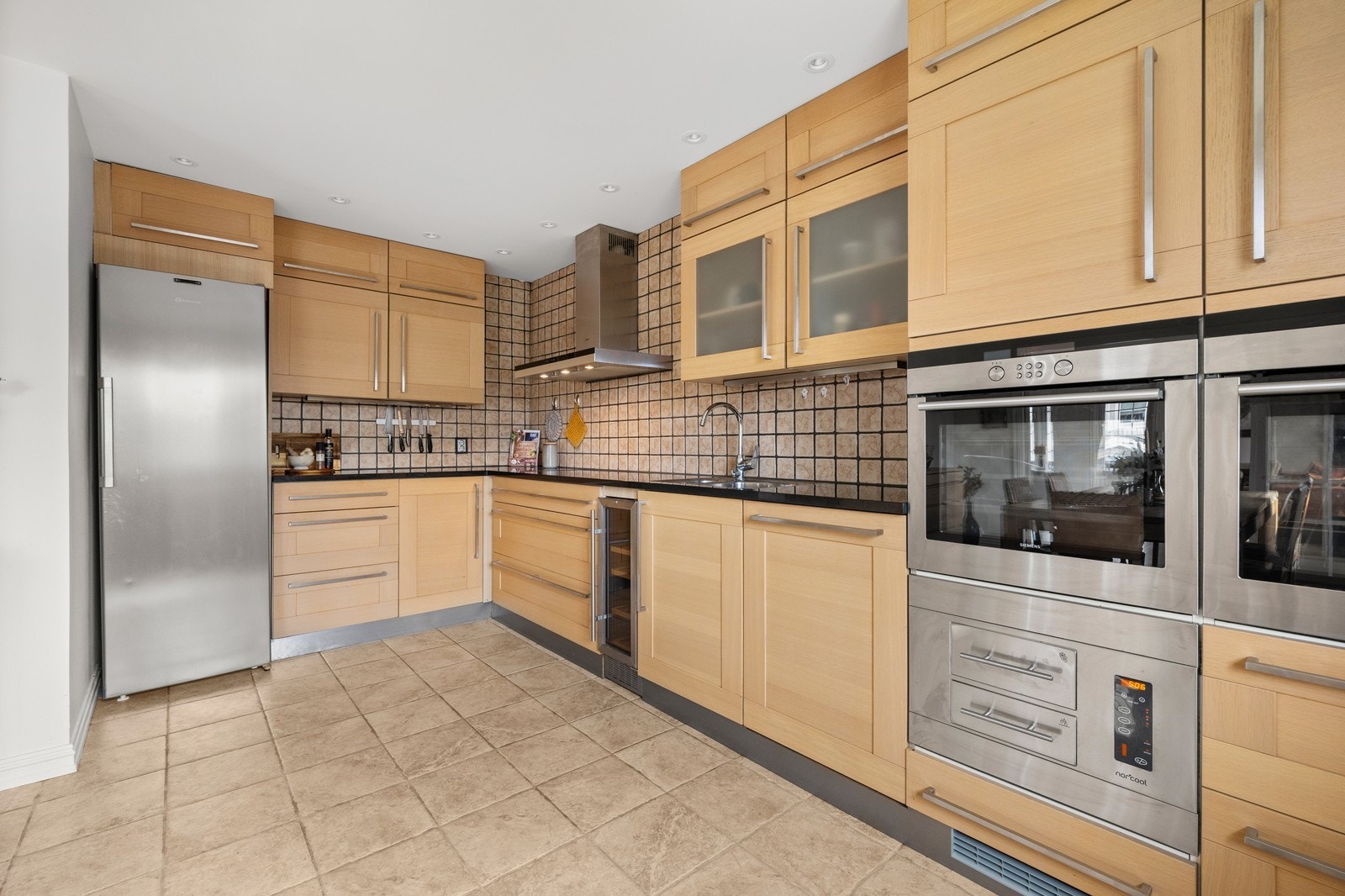 Mye skapplass på kjøkkenet. Flislagte gulv og downlights i taket. Galleribilde