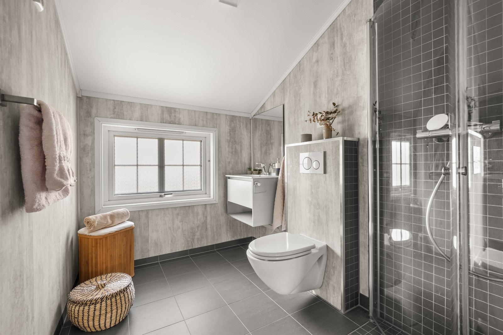 Bad 2. etasje med flislagte gulv, vegghengt toalett og dusjhjørne. Galleribilde