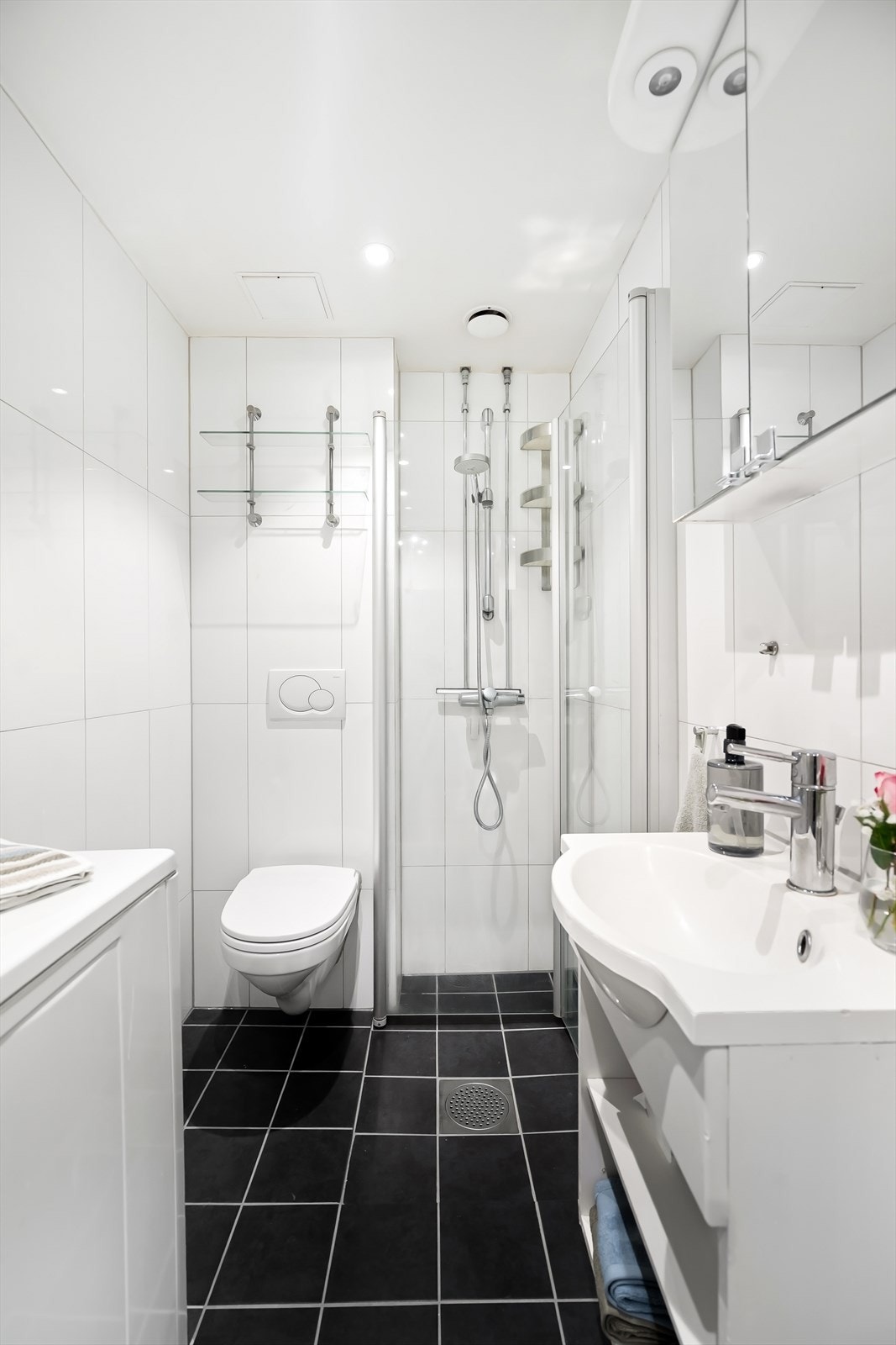 Baderom fra ca. 2009 i regi av borettslaget med opplegg for vaskemaskin, flislagt gulv med gulvvarme (fra 2025), flislagte vegger og nedsenket himling med downlights. Galleribilde