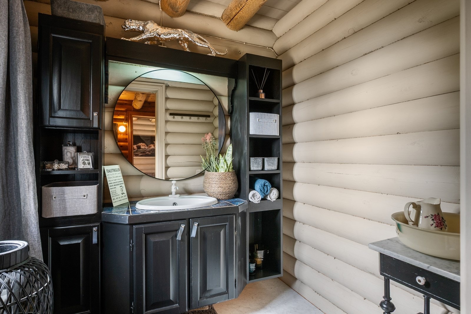 En sort skapinnredning sørger for god oppbevaringsplass, og et tidsriktig speil gir rommet et moderne uttrykk. Galleribilde
