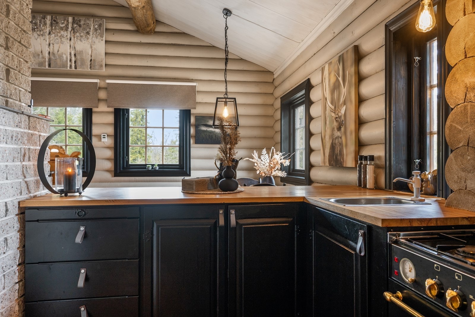 Kjøkkenet har klassisk, sort innredning og benkeplate i heltre. Galleribilde