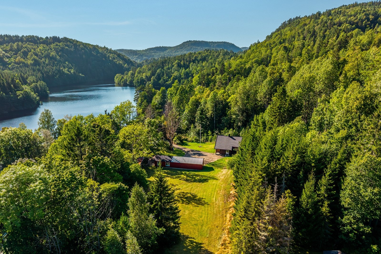 Skogen og åsene rundt skaper en fredelig og skjermet ramme om eiendommen. Galleribilde