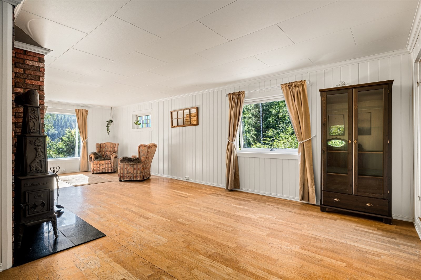 Stuen har godt lysinnslipp og gir en lun atmosfære med vedovn. Galleribilde