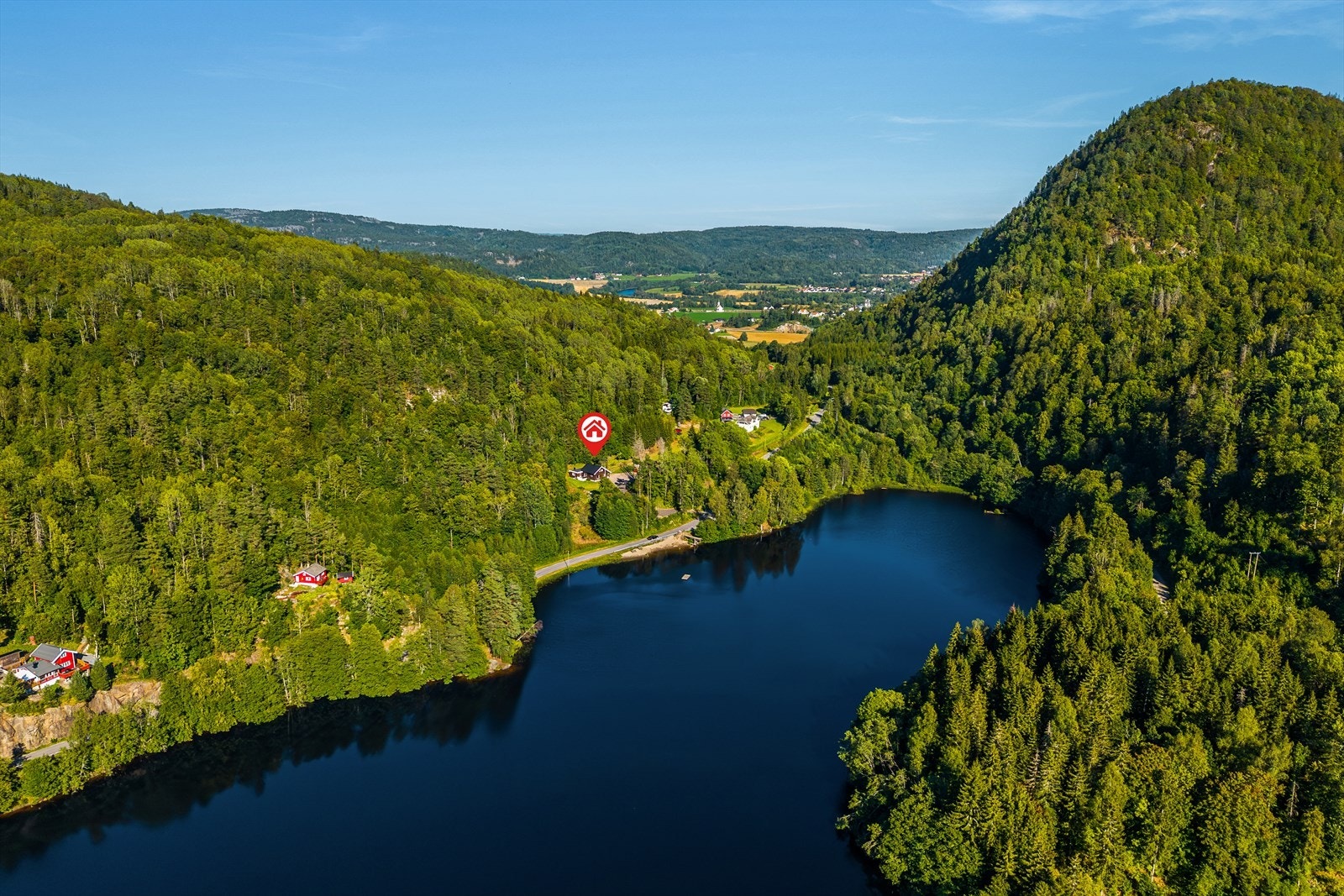 Dronebilde som viser eiendommens naturskjønne beliggenhet ved vannet. Galleribilde