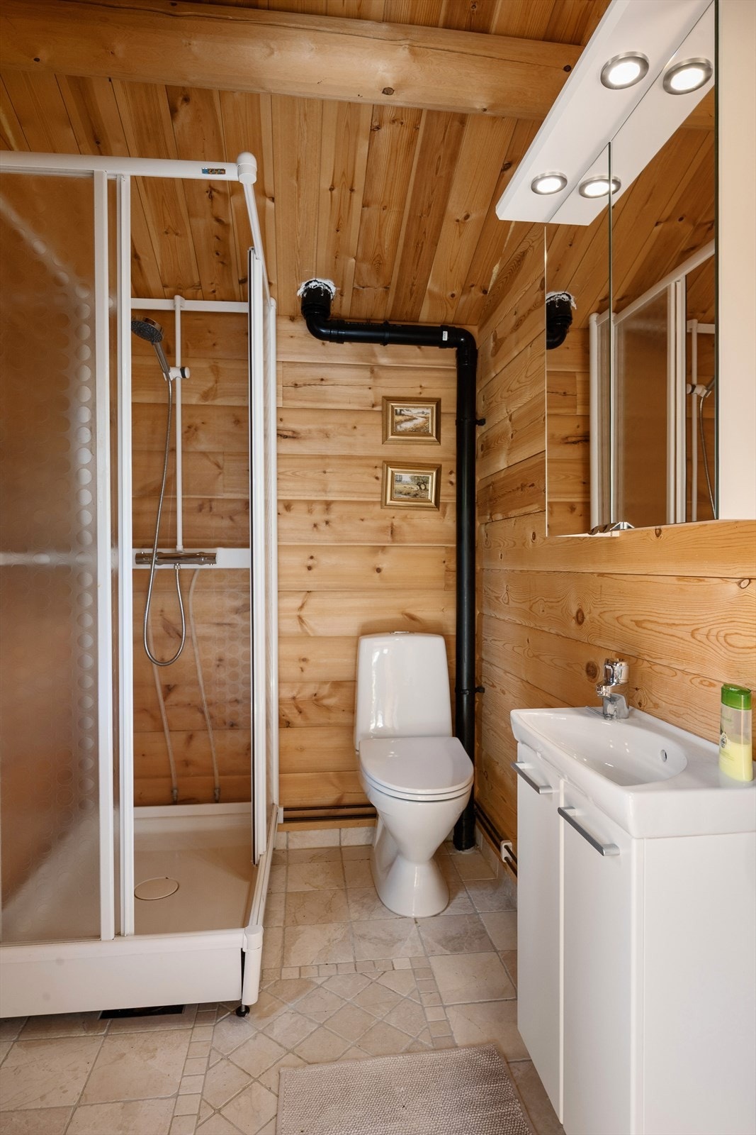 Badet er innredet med dusjkabinett, servant og toalett. Galleribilde