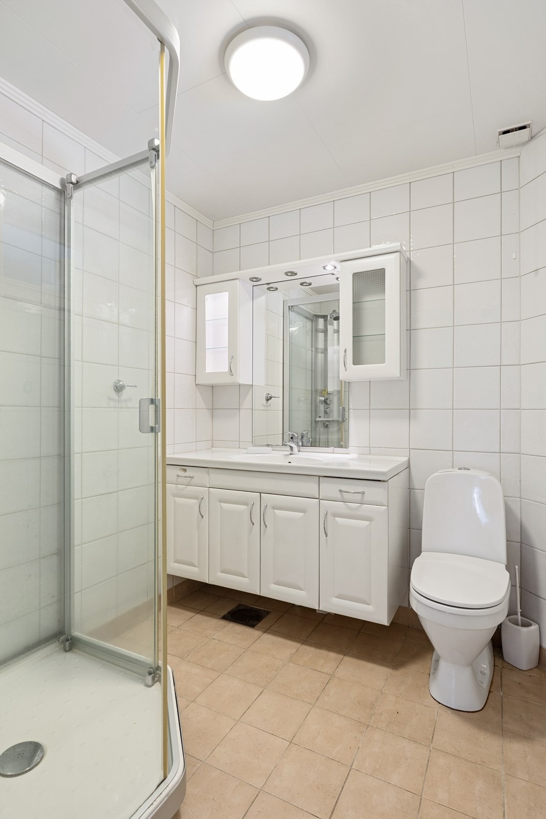 Baderomsinnredning med heldekkende servant. Utstyrt med toalett og dusjkabinett. Naturlig ventilering. Galleribilde