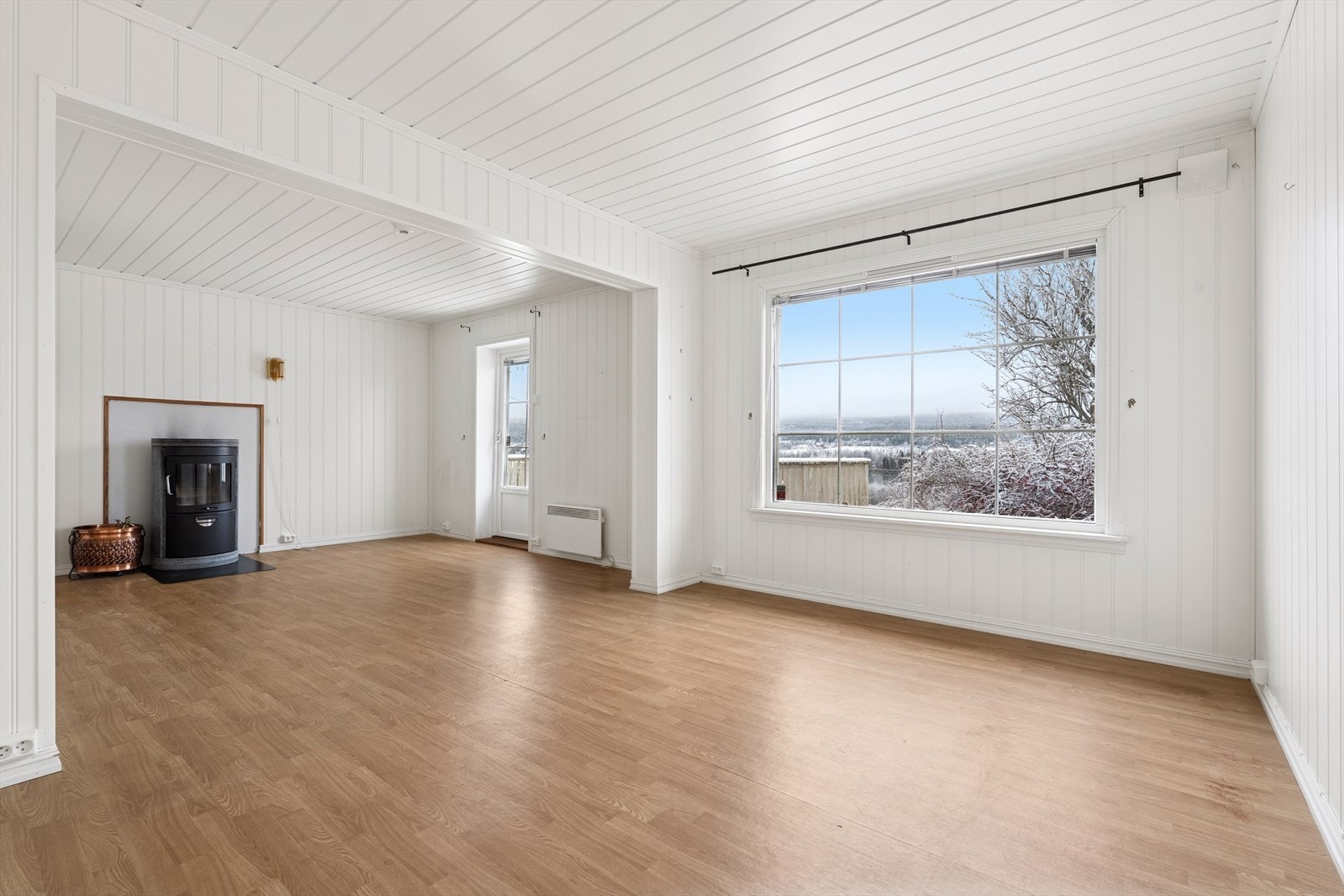 Romslig stue med gode innredningsmuligheter til sofagruppe og tv-møblement. Peisovn. Store vindusflater som lar dagslyset flyte fritt. Galleribilde