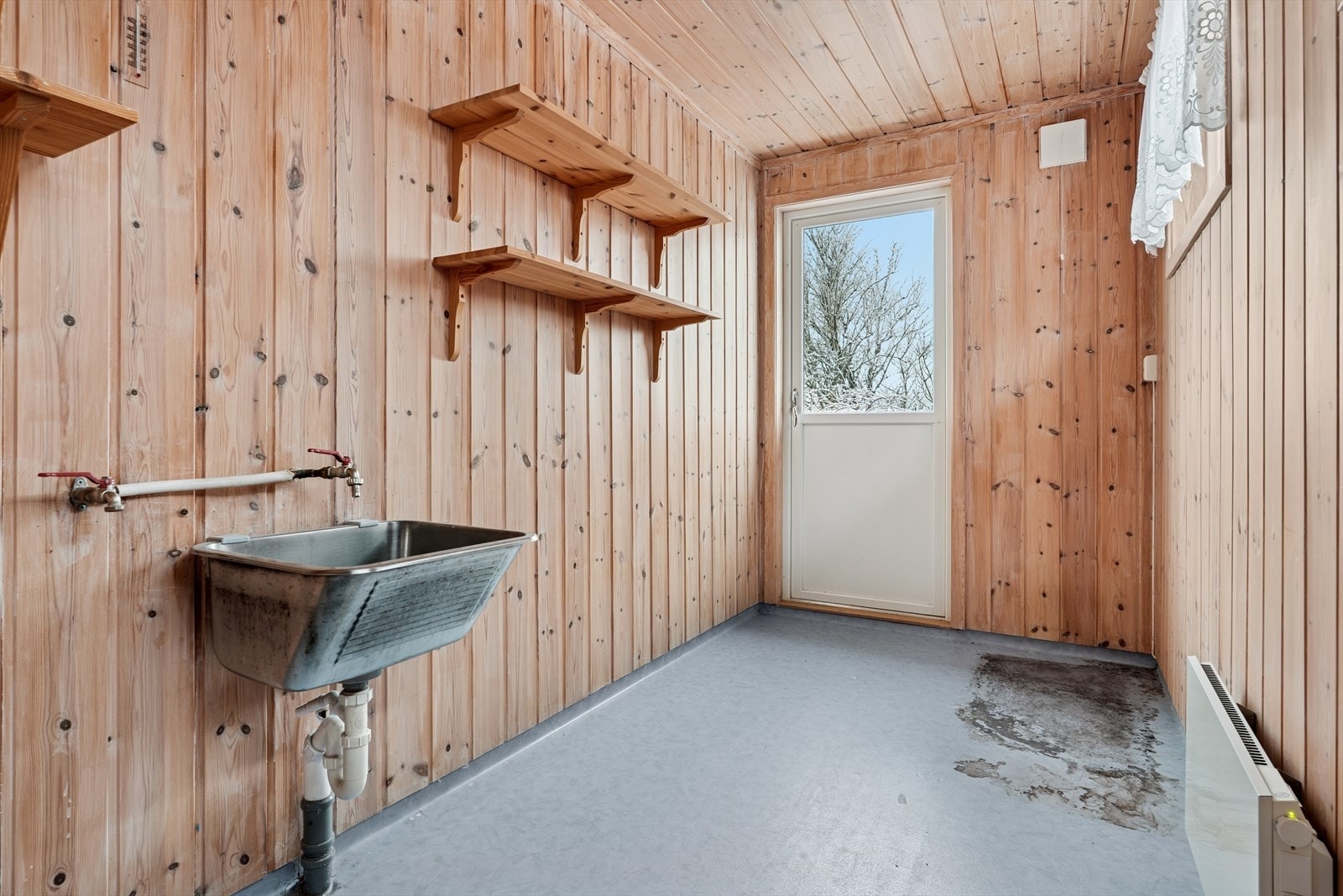 Rom som idag er innredet som vaskerom, ikke søkt godkjent. Vegger og himling har panel. Gulvet har vinylbelegg med oppkant mot vegger og mot dører. Panelovn som varmekilde. Egen praktisk utgang. Galleribilde