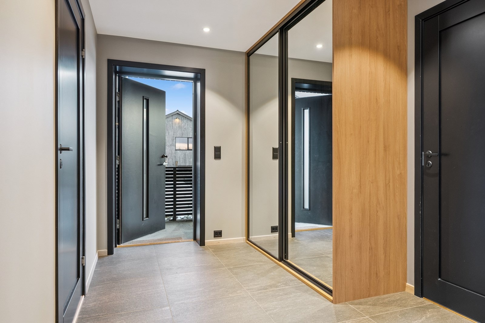 Flislagt og romslig entré med praktisk skyvedrøsgarderobe som medfølger handelen. Galleribilde