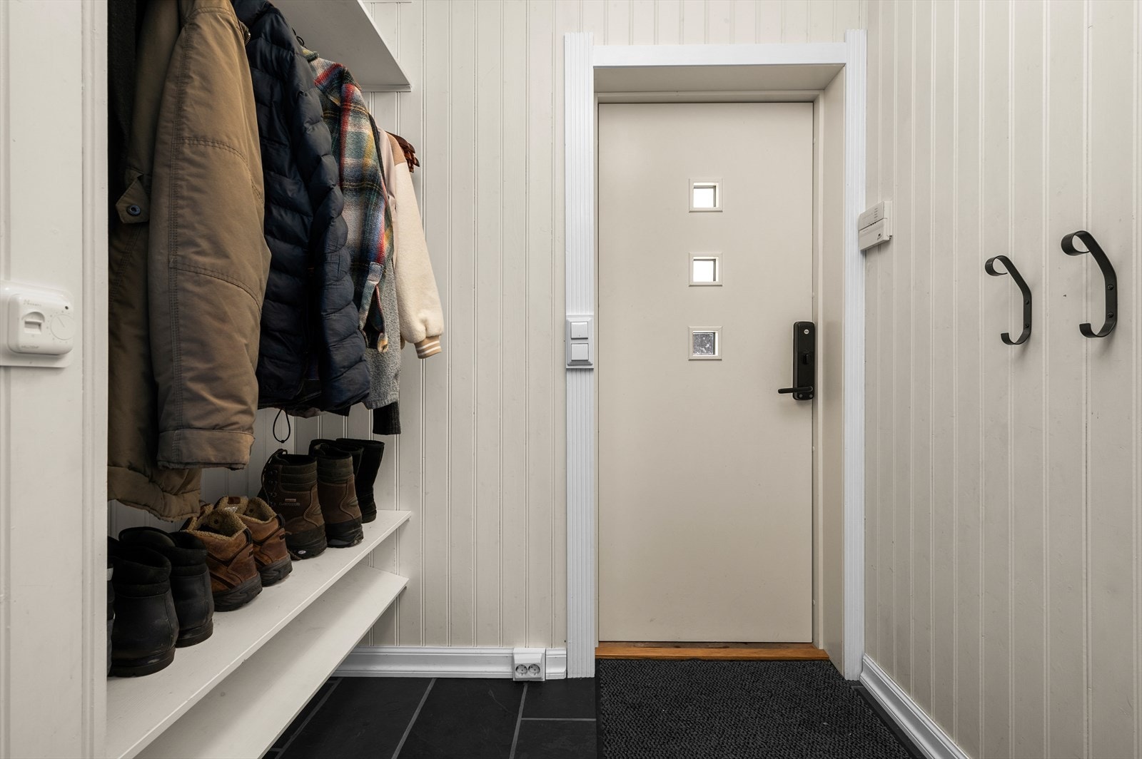 Åpen og lys entrè med gode muligheter for å henge fra seg yttertøyet og sko. Galleribilde