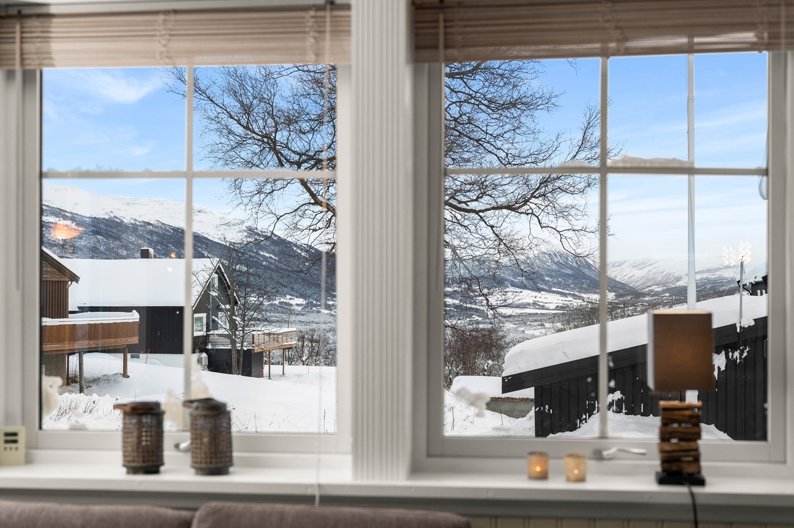 Stuevinduet rammer inn naturskjønne omgivelser med snødekte fjell og hytter om vinteren, og frodig natur og grønne landskap i sommerhalvåret. Galleribilde