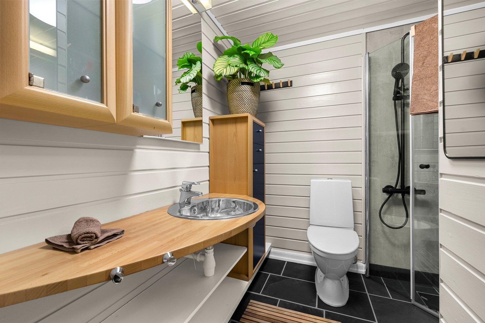 Badet måler 3,5 m² og er innredet med toalett, dusjhjørne og servant. Galleribilde