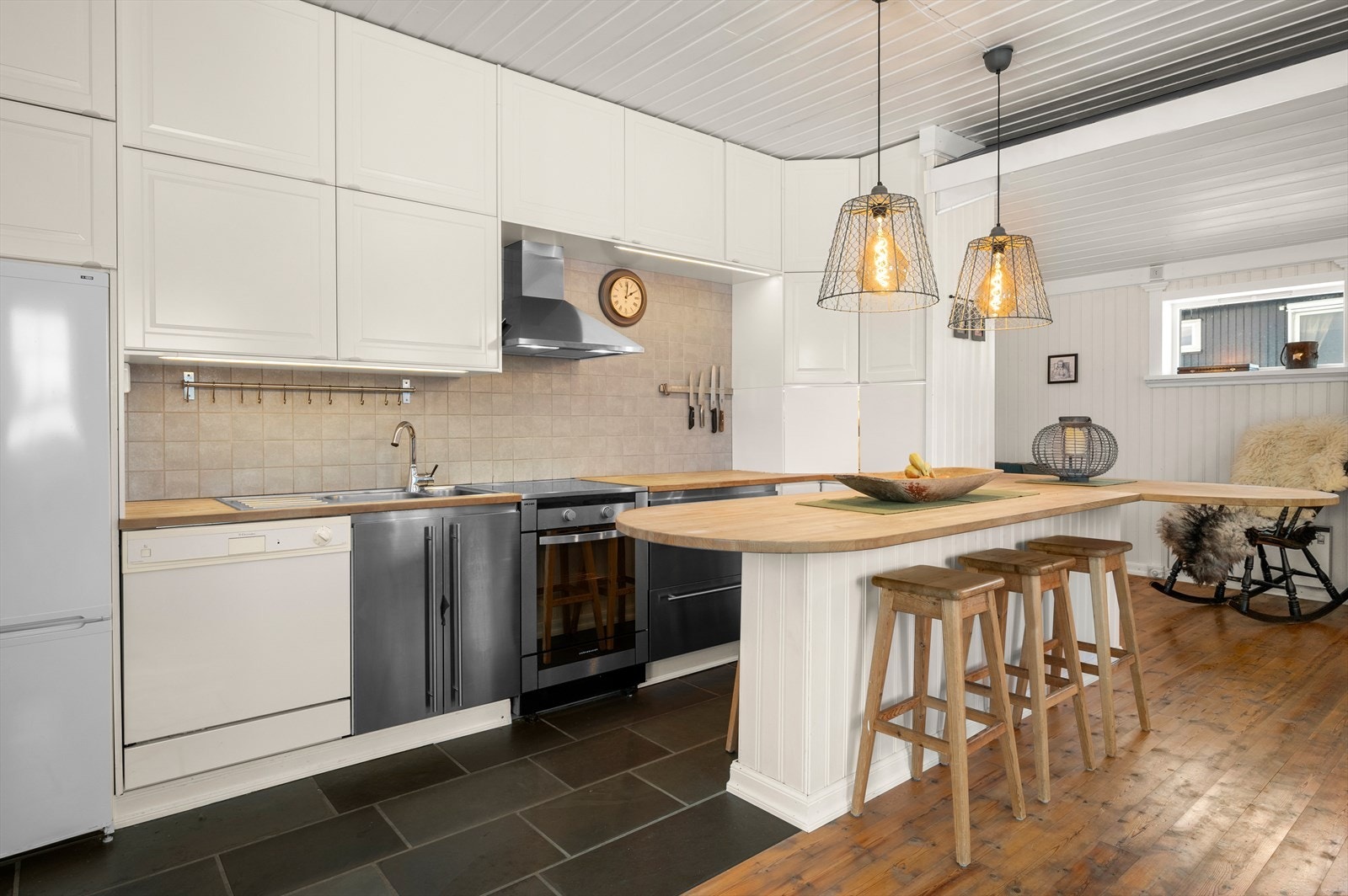 Kjøkken i lyse farger, med generøs benkeplass og rikelig med oppbevaringmuligheter. Galleribilde