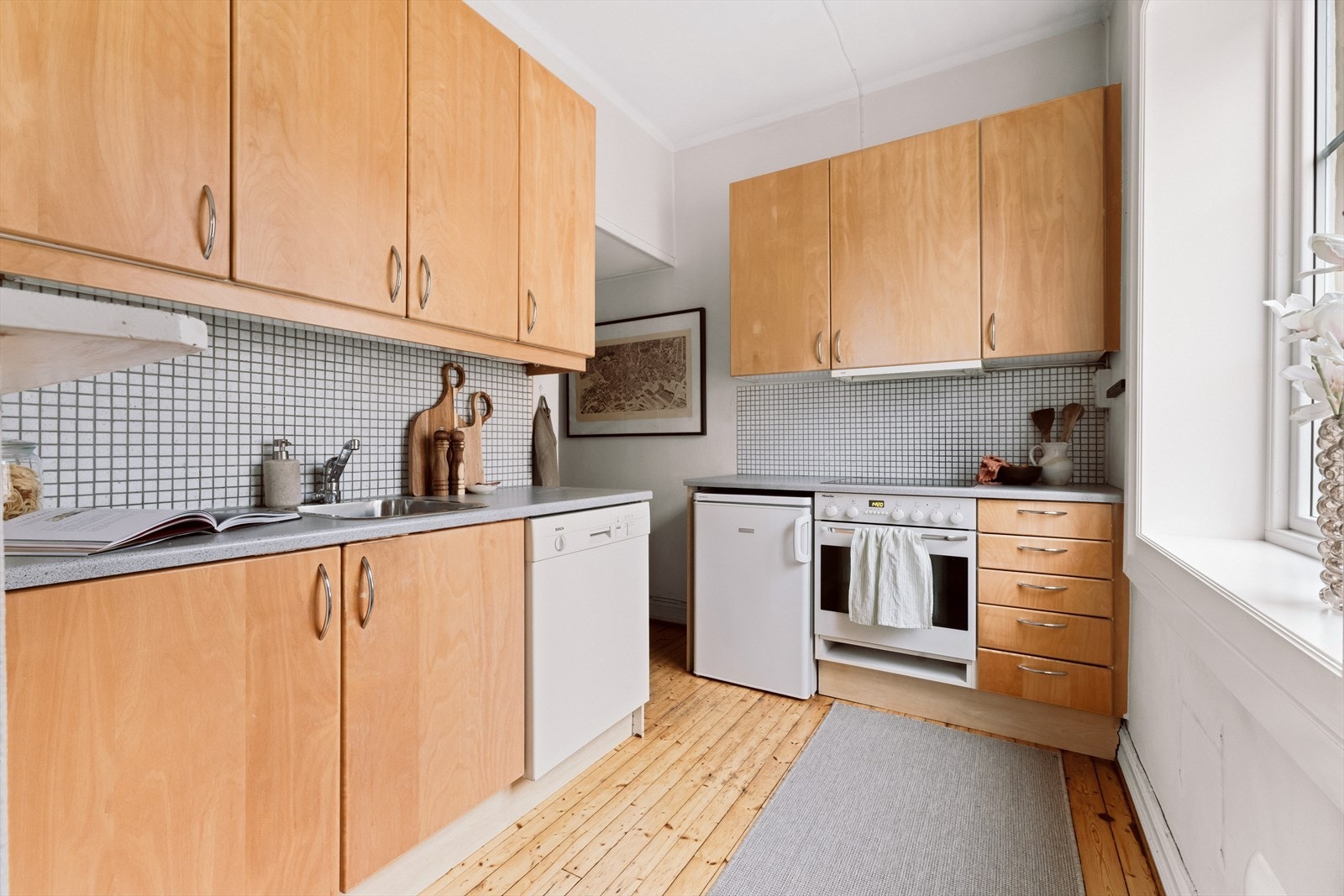 Kjøkkenet har en funksjonell innredning med glatte, finerte fronter og god skapplass. Galleribilde