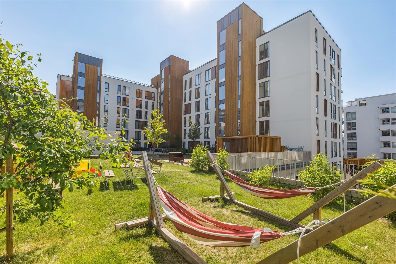 Bakgårdshagen fremstår idyllisk og frodig, med flere hyggelige sittegrupper Galleribilde