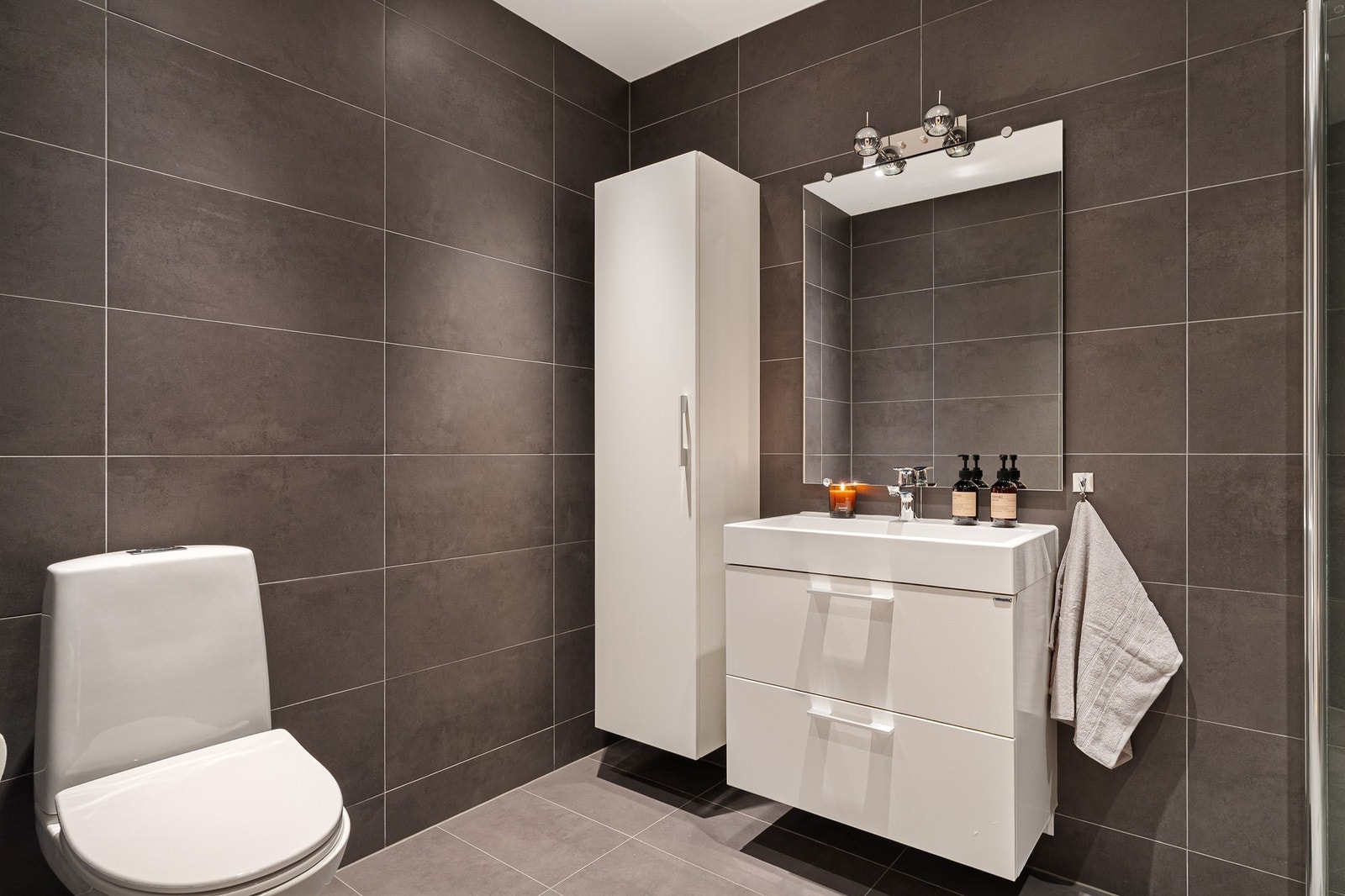 Rommet er utstyrt med varme i gulv, dusjhjørne med innfellbare dører, toalett og godt med lagring i høyskap og servantskap. Galleribilde