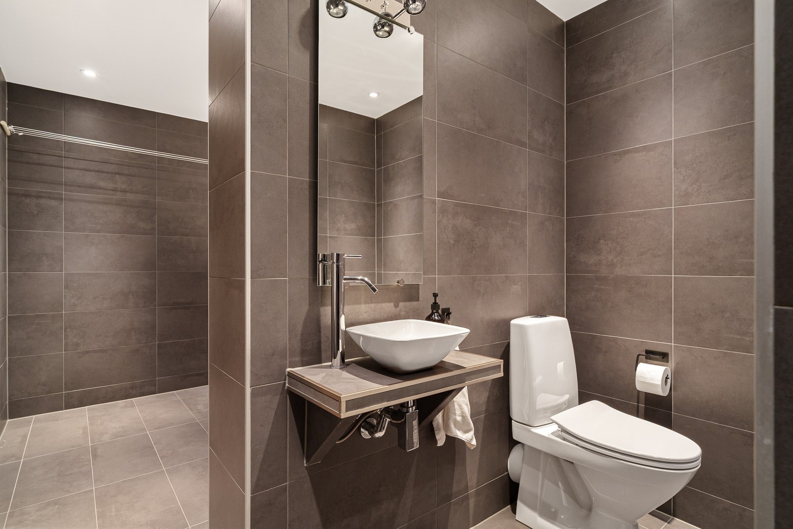 Bad/vaskerom, er utstyrt med dusjnisje, badekar, toalett og vask. Vaskeromsdelen har god plass til oppbevaring og tørk, i tillegg til utslagsvask. Galleribilde