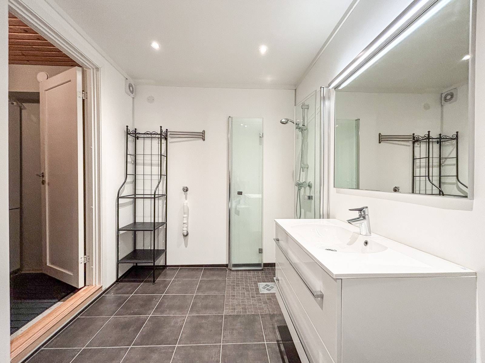 Badet har fliser på gulvet og baderomsplater på veggene. Galleribilde