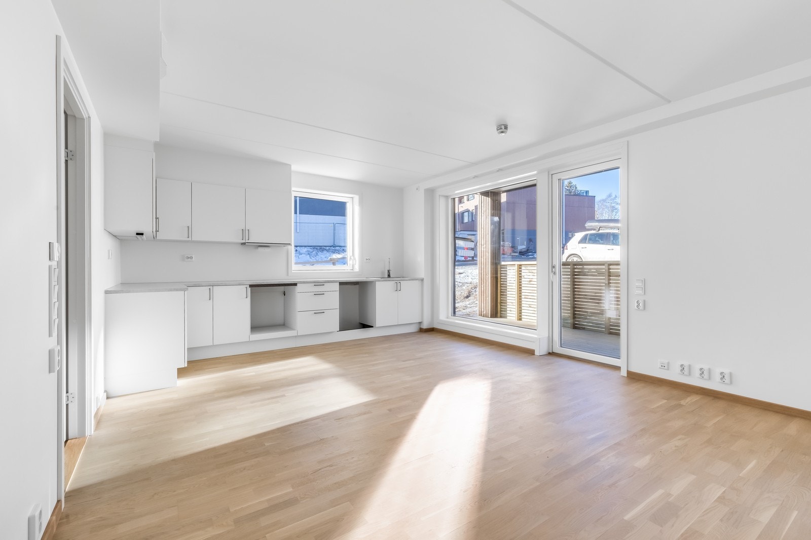 Kjøkken i åpen løsning med stuen, det er satt inn komfyr, oppvaskmaskin og kombiskap. Galleribilde