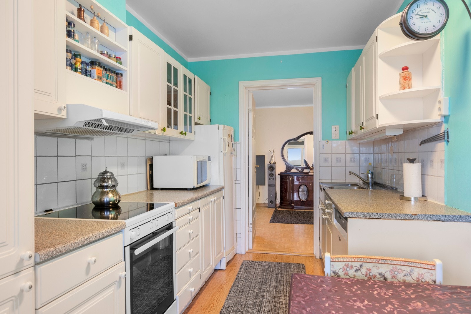 Kjøkkenet har laminat benkeplate, profilerte fronter og flisbelagt vegg over benkeplate. Det er stålvask med ettgreps- blandebatteri og kjøkkenventilator med avtrekk ut. Galleribilde