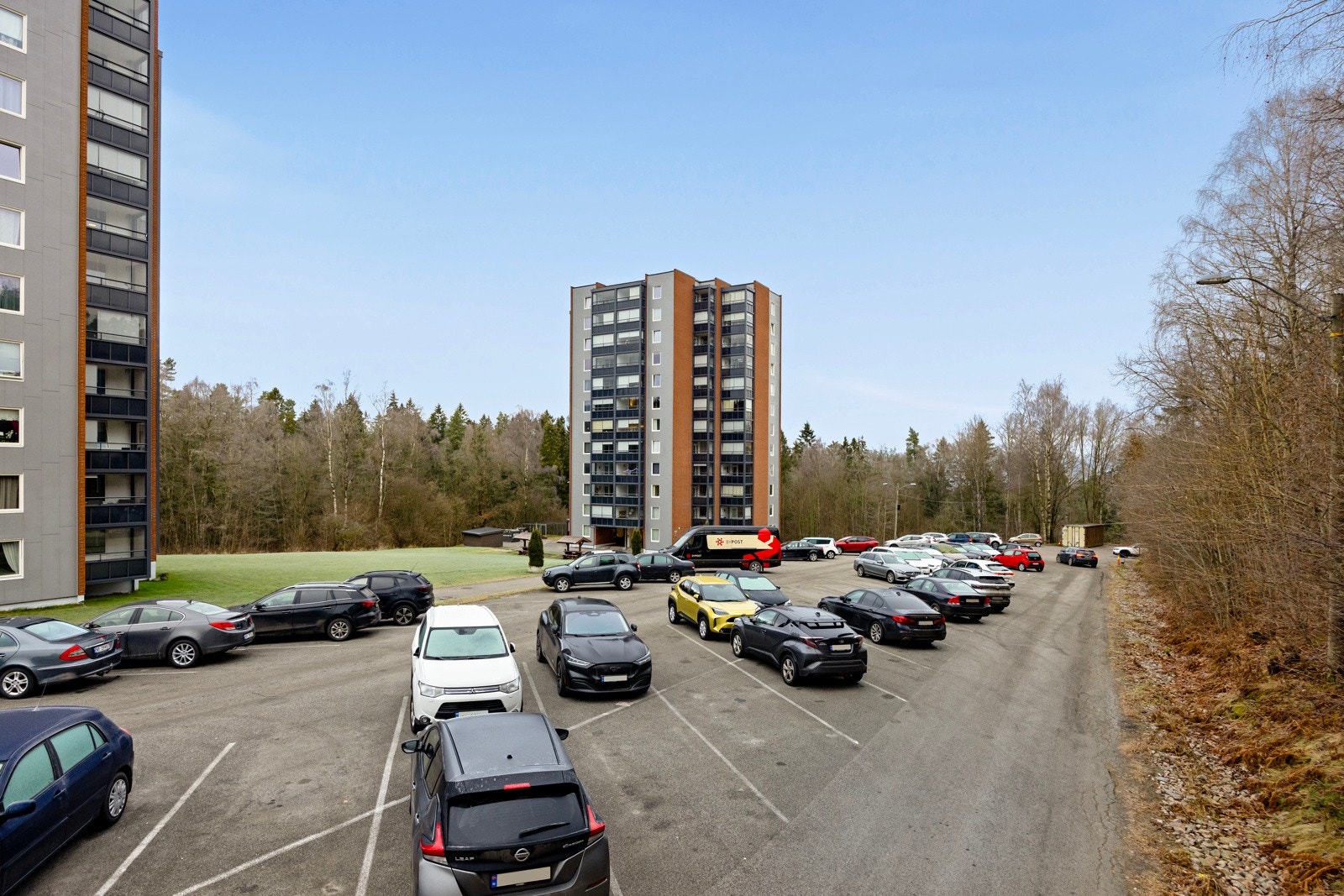 Parkering på felles asfaltert parkeringsplass. Det er også montert elbil-ladere. Galleribilde