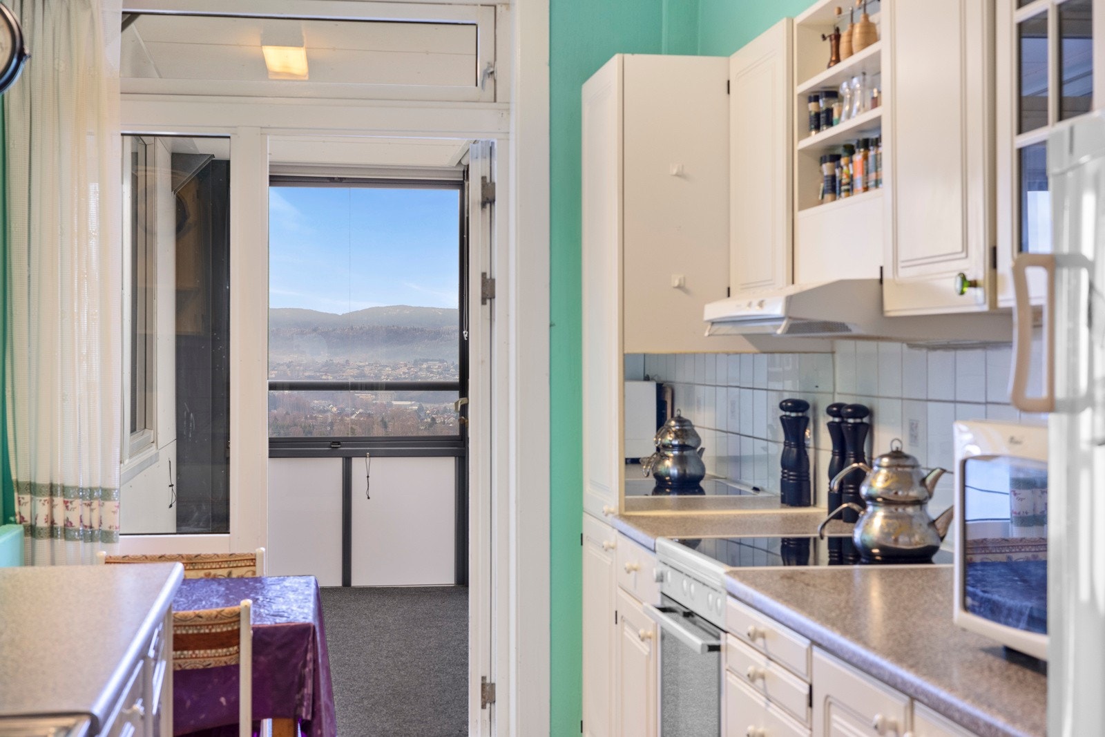 Fra kjøkkenet er det utgang til innglasset balkong med teppegulv og persienner. Galleribilde