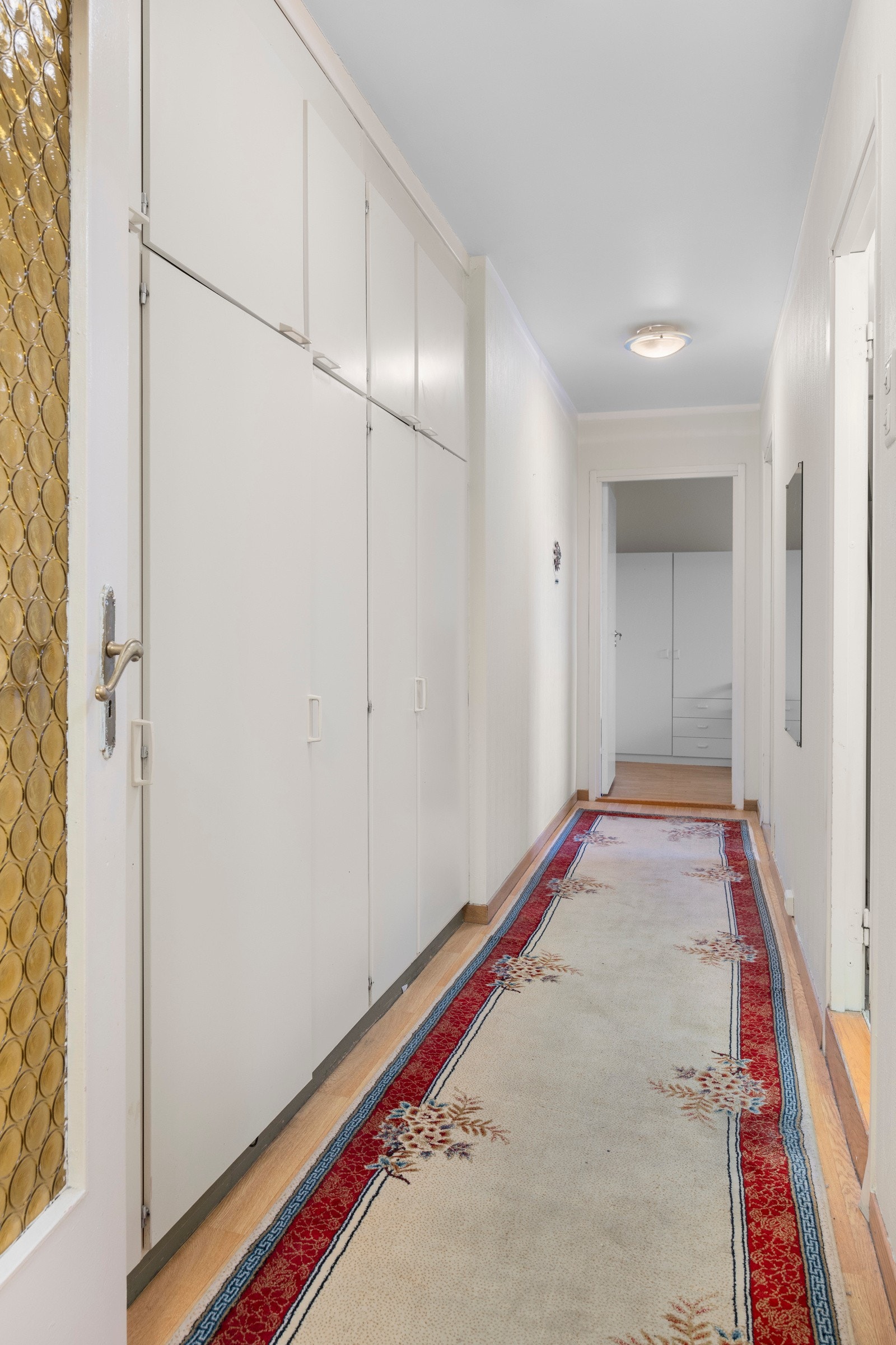 Fra entreen kan du gå til venstre inn i gangen som fører til toalettrom, bad og to soverom. Gangen har innebygde skap. Galleribilde