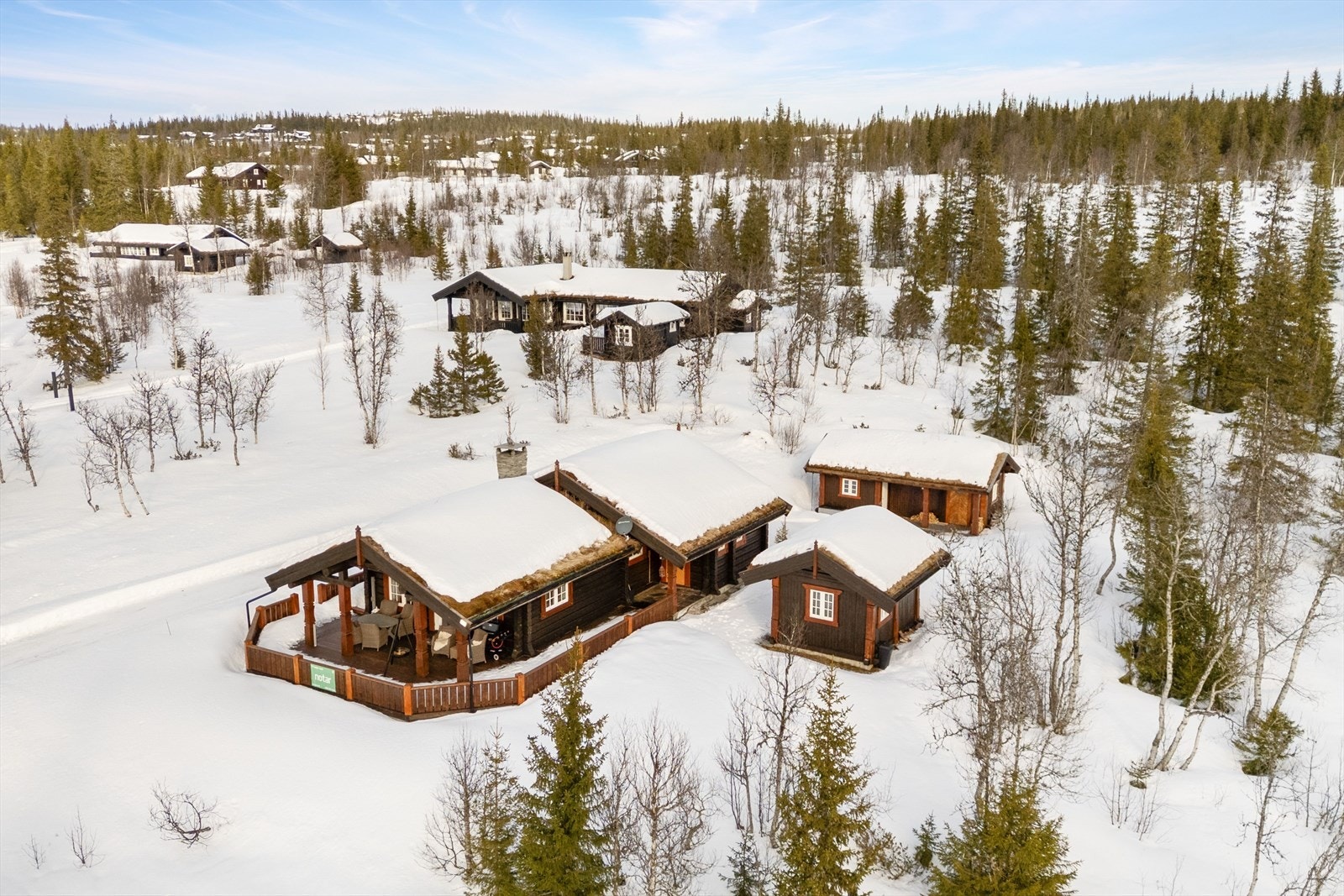 Hytta ligger omgitt av vinterlandskap med nærhet til skog og fjell. Galleribilde